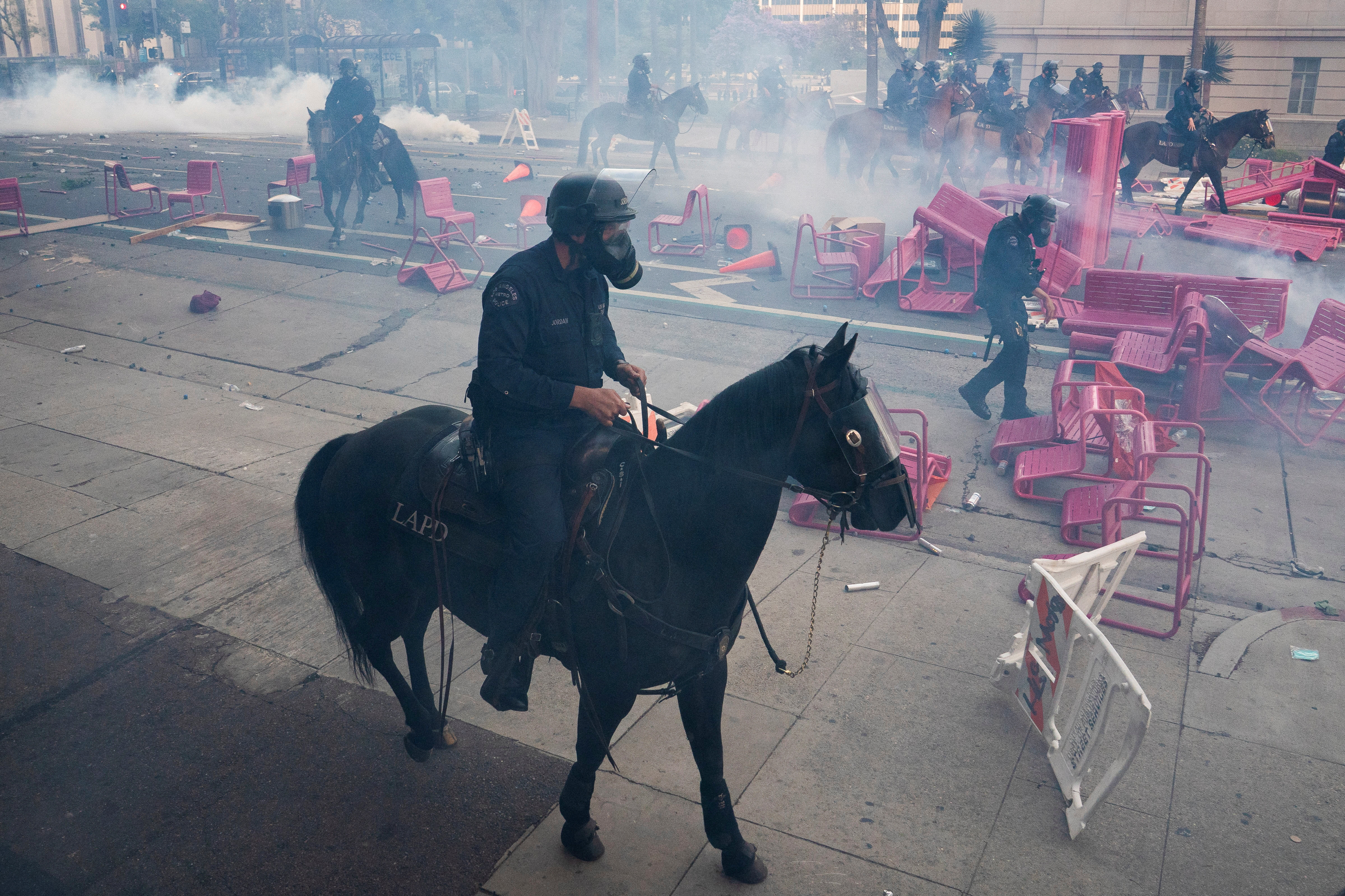 Police clear demonstrators after they blocked a street with a barricade during a protest against federal immigration sweeps in downtown Los Angeles.