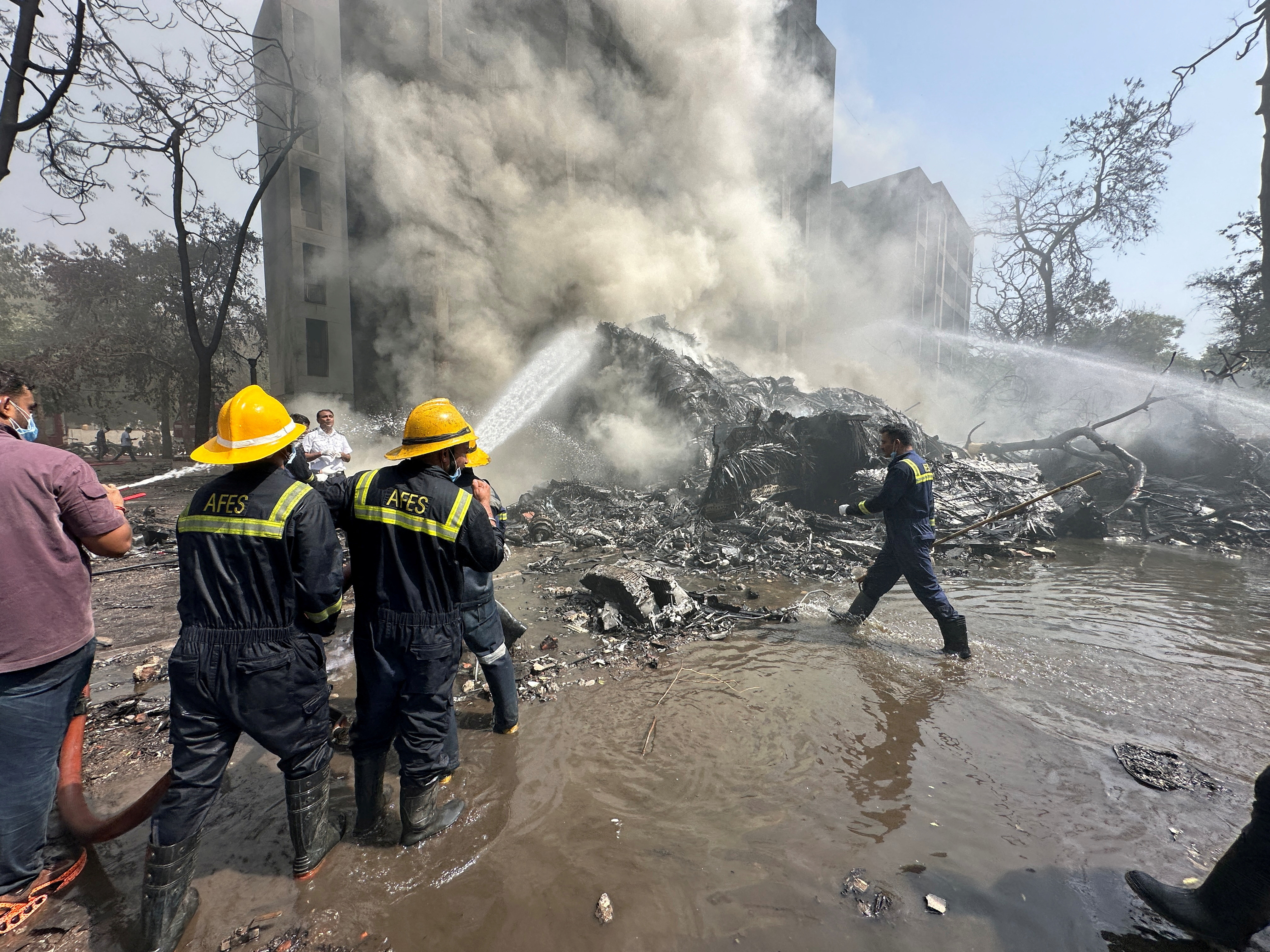 Firefighters work at the site of a plane crash in India's northwestern city of Ahmedabad