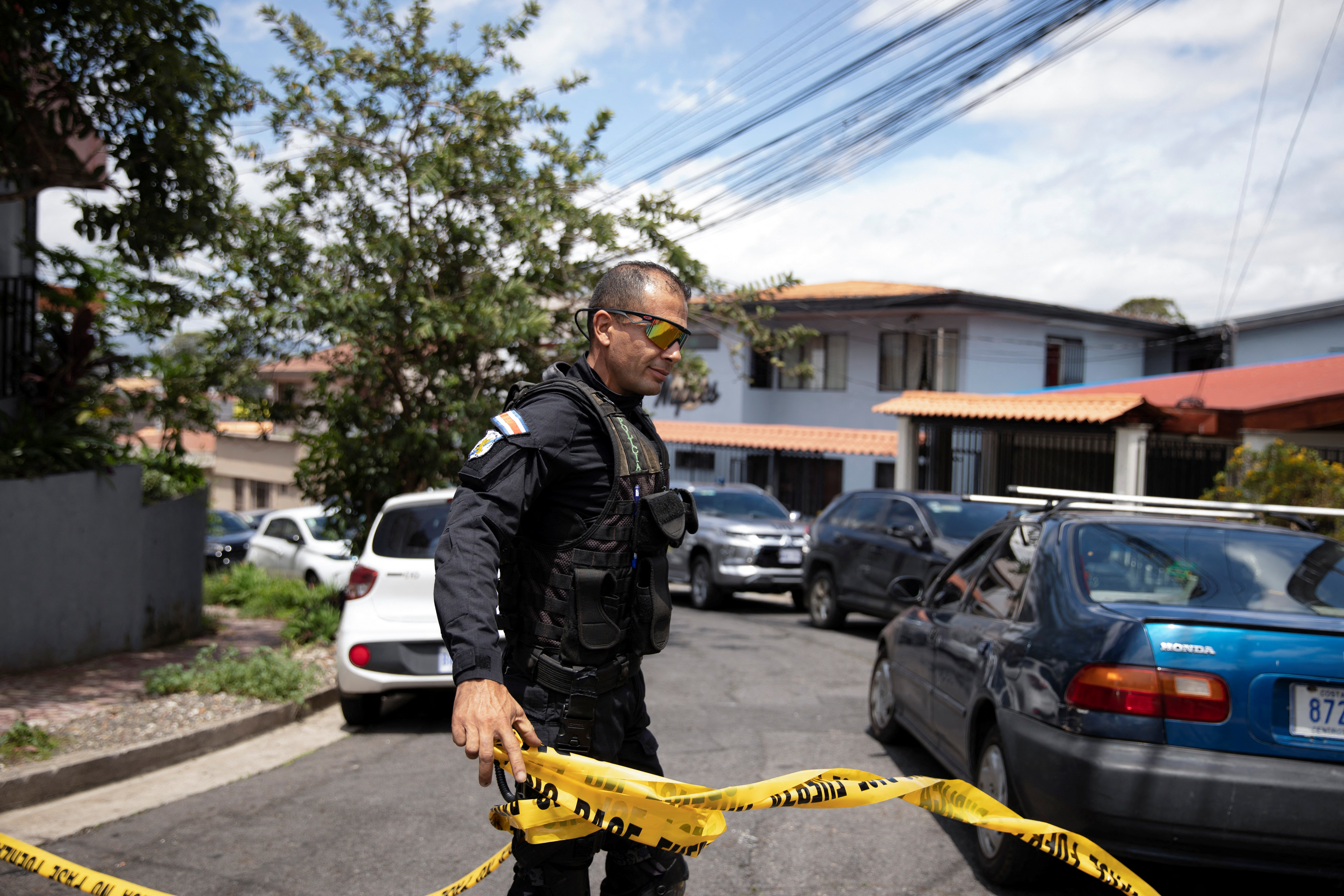 A officer holds a roll of police tape.