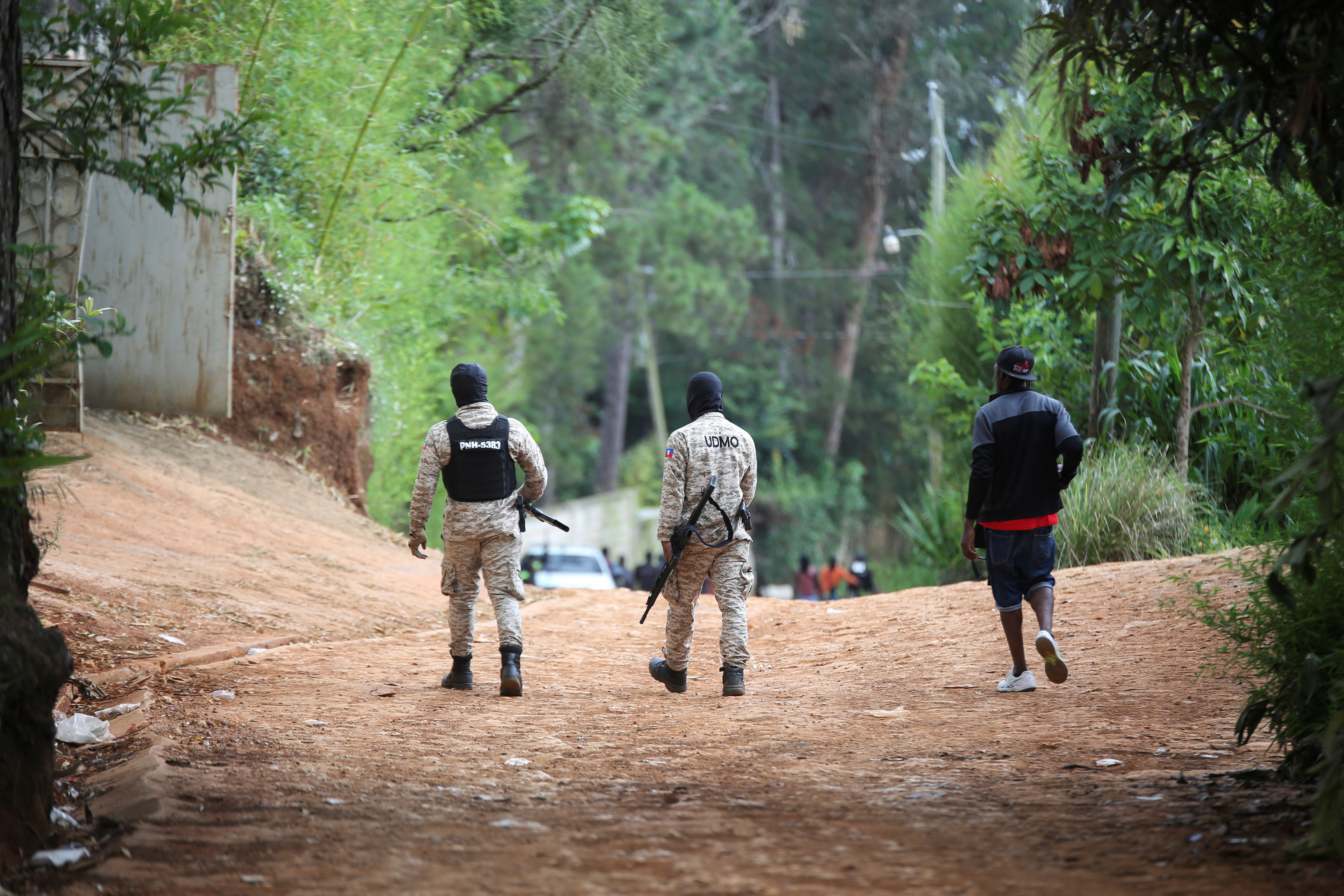 Police officers and a neighbourhood watch member walk outside a police station that they share, at a residential area after gangs torched homes, amid a surge in violence that has displaced approximately 1.3 million people in six months, according to U.N. estimates, in Furcy, Haiti June 24, 2025. On Friday, the Trump administration announced that Haitian migrants would no longer get special protections and should return home to their country. [Reuters/Jean Feguens Regala]