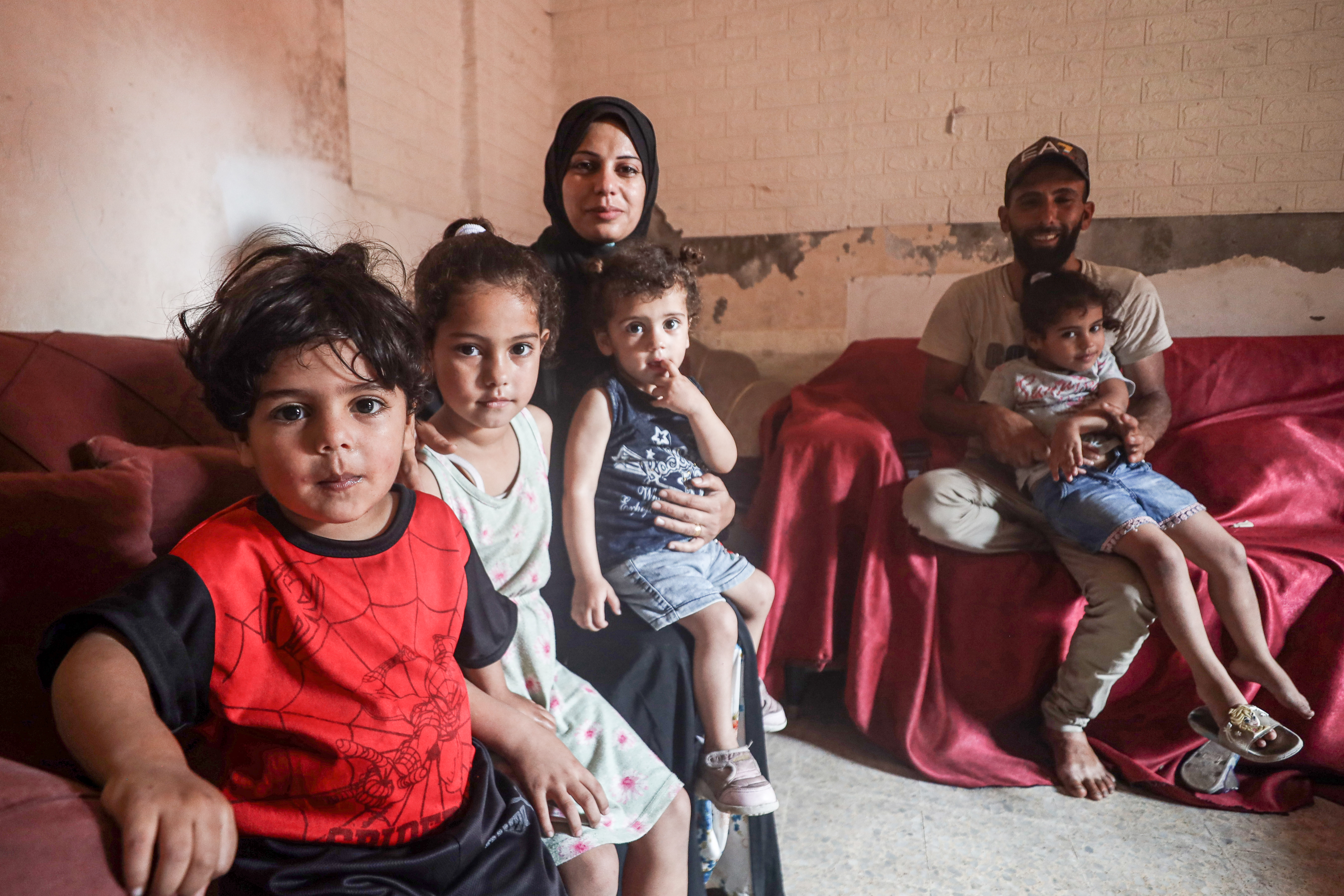 Madleen Kulab sits with her children in Gaza