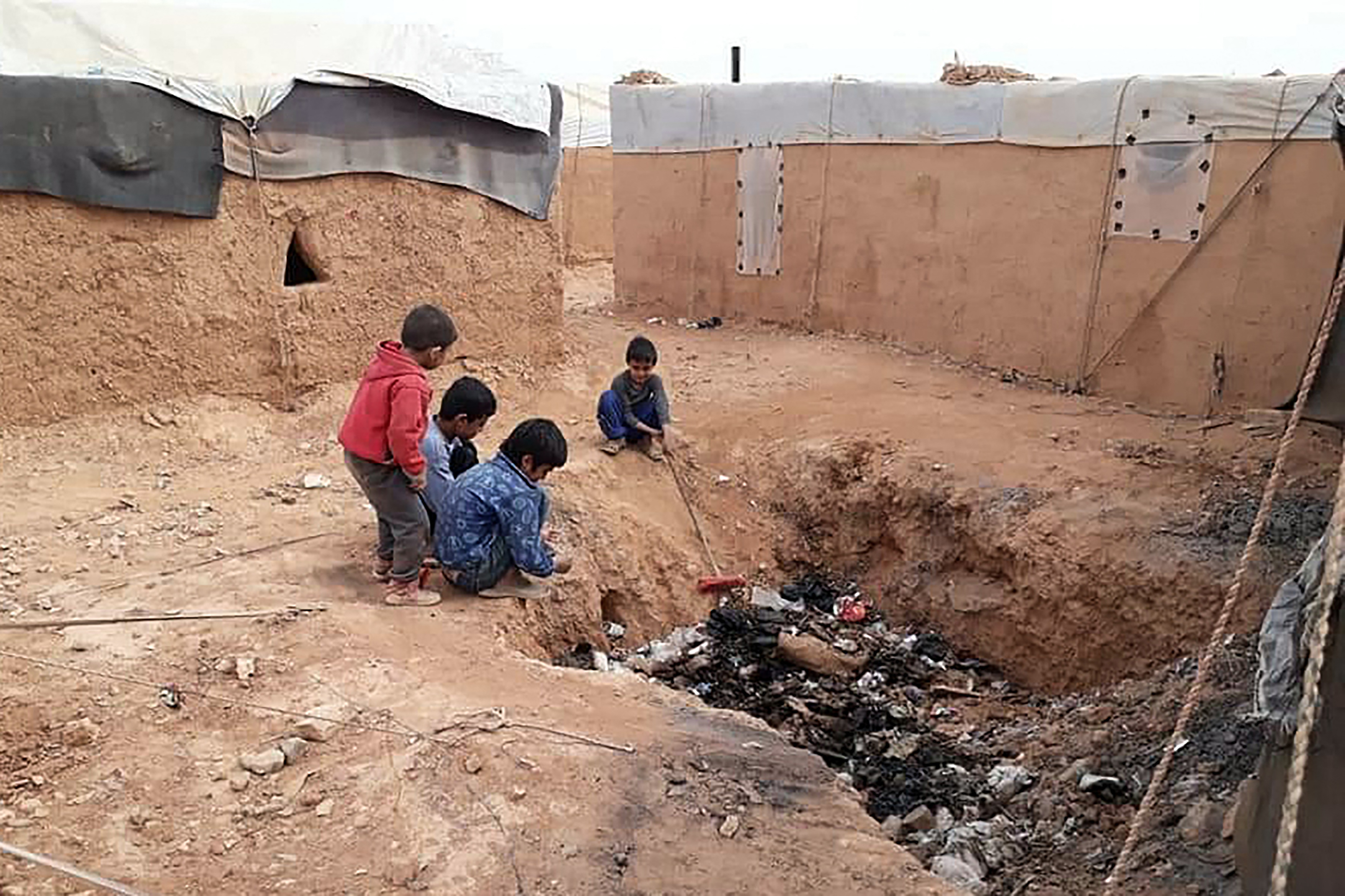 A handout picture provided by the Syrian Emergency Task Force (SETF) on May 17, 2024, shows displaced Syrian children playing near a rubbish dump at the Rukban camp