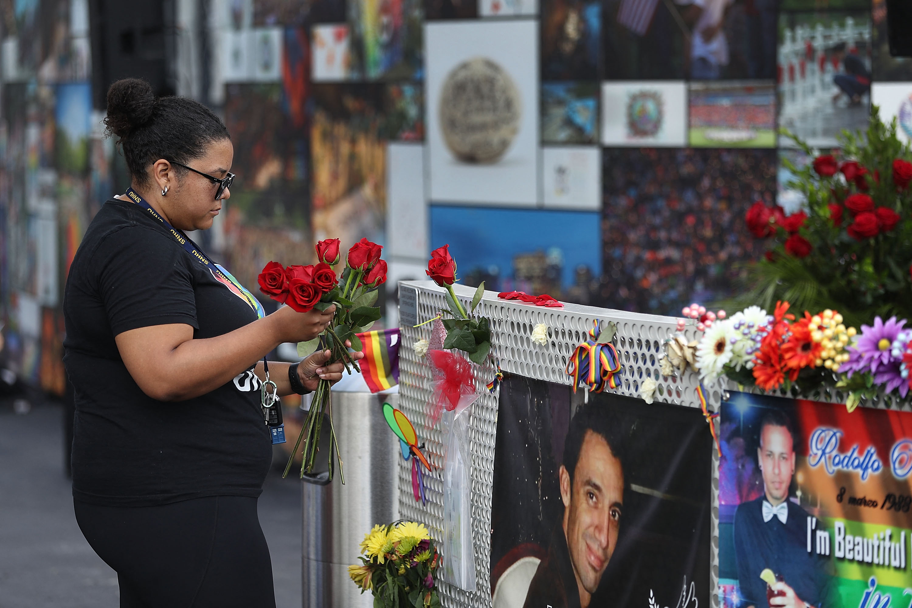 A mourner places flowers on a fence at the memorial set up for the shooting victims at Pulse nightclub on June 12, 2018 in Orlando, Florida, US.