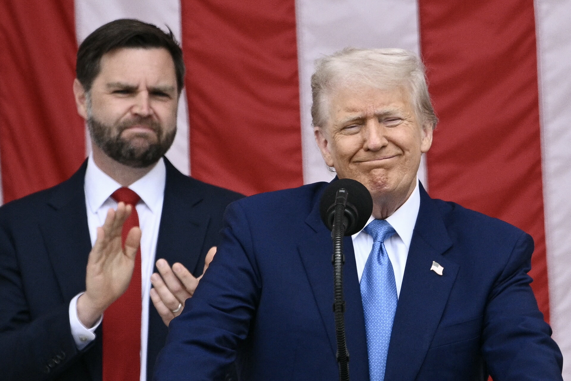 US President Donald Trump delivers remarks as US Vice President JD Vance looks on at the National Memorial Day Observance at the Memorial Amphitheatre in Arlington National Cemetery in Arlington, Virginia, on May 26, 2025. (Photo by Brendan SMIALOWSKI / AFP)