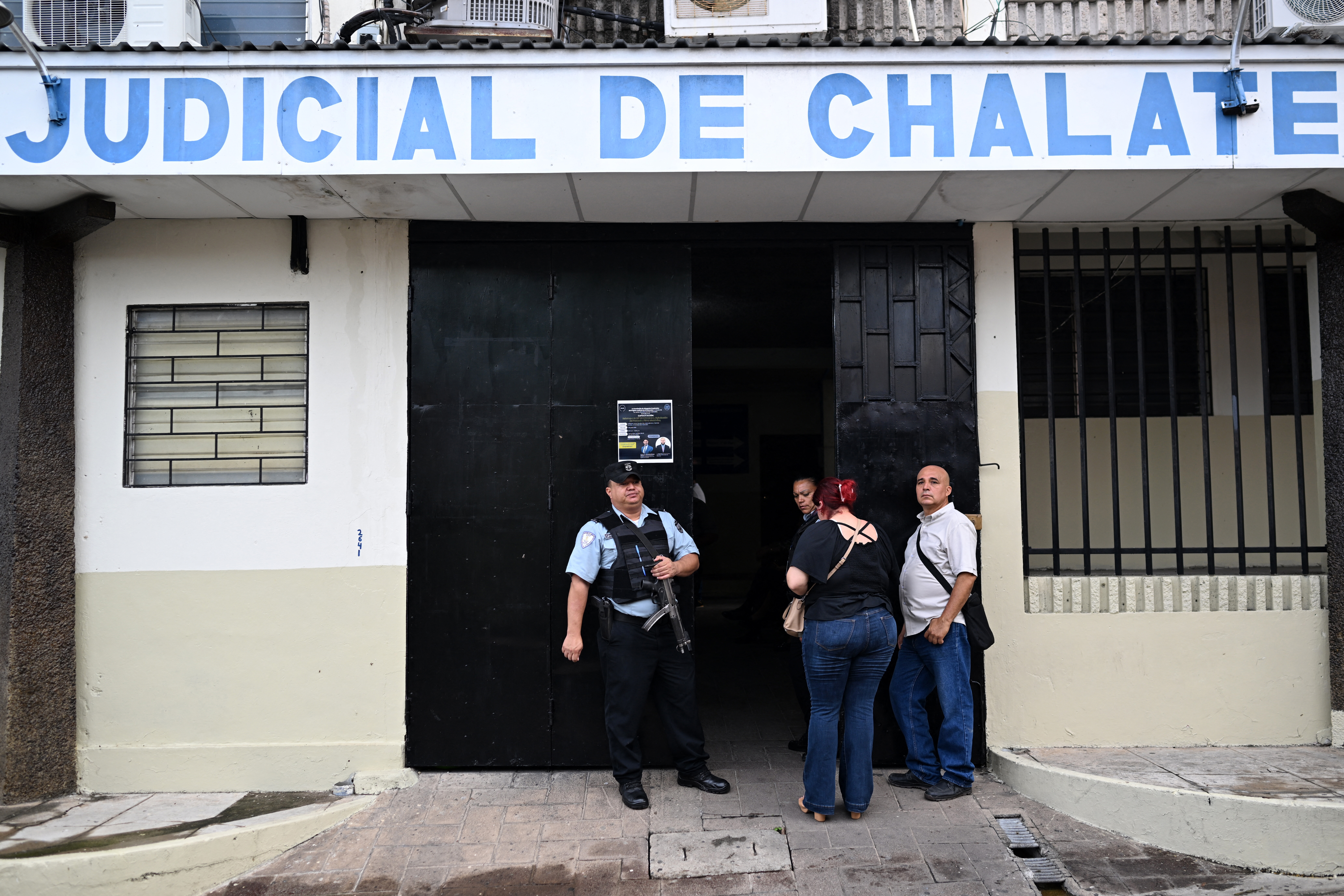 Guards stand guard at the entrance to the Chalatenango Judicial Center, where a public hearing is being held against former military officers accused of ordering the murder of four Dutch journalists during El Salvador's civil war (1980-1992) in Chalatenango, El Salvador on June 3, 2025. On March 17, 1982, journalists Koos Andries Koster, Jan Cornelius Kuiper, Hans Lodewijk ter Laag and Johannes Jan Wilemsen were ambushed and killed by members of a Salvadoran armed force battalion in Santa Rita, Chalatenango, El Salvador. (Photo by Marvin RECINOS / AFP)