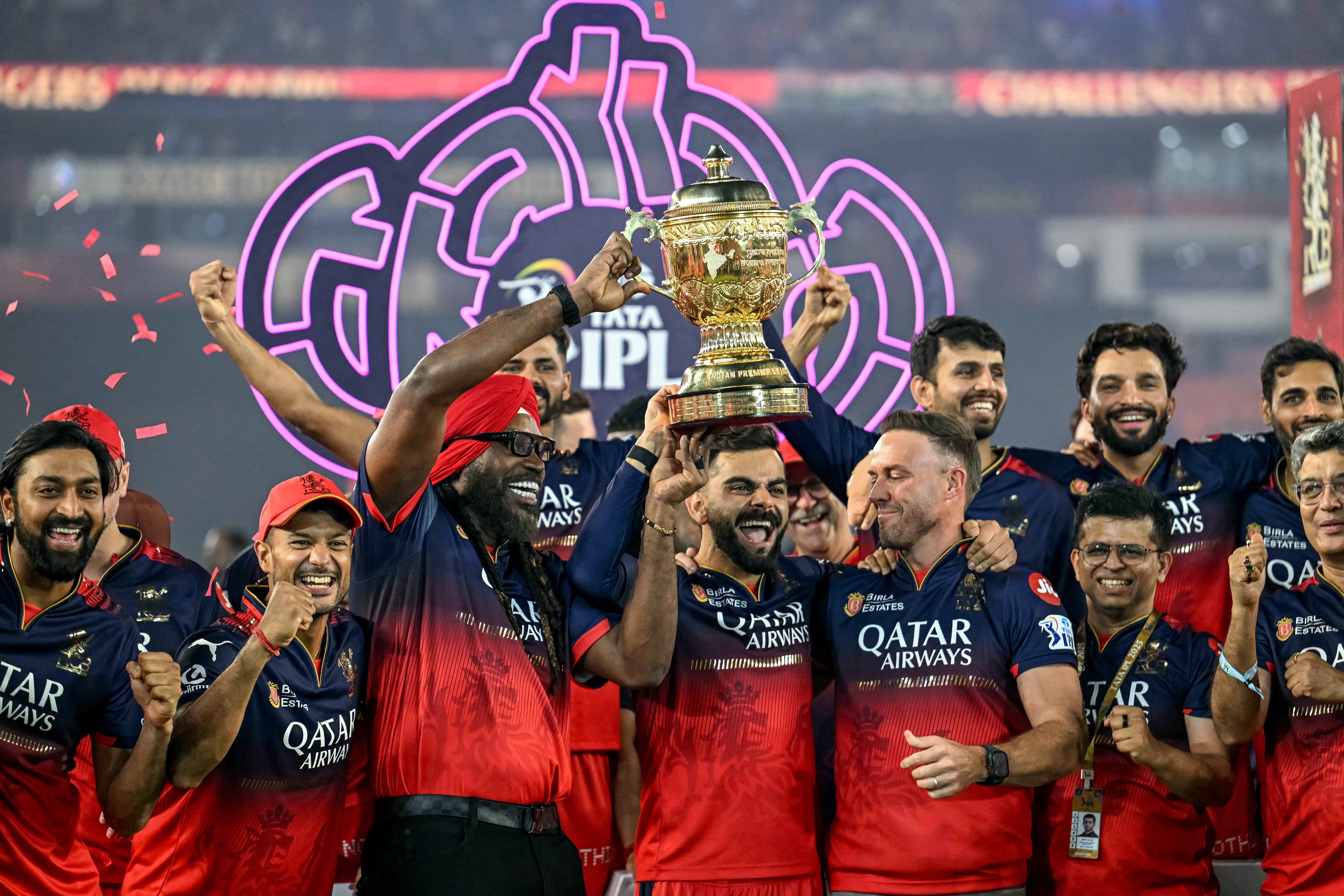 Royal Challengers Bengaluru's Virat Kohli (C), along with his former teammates AB de Villiers (centre R) and Chris Gayle (centre L), celebrates with the trophy after winning the Indian Premier League (IPL) Twenty20 final cricket match against Punjab Kings at the Narendra Modi Stadium in Ahmedabad