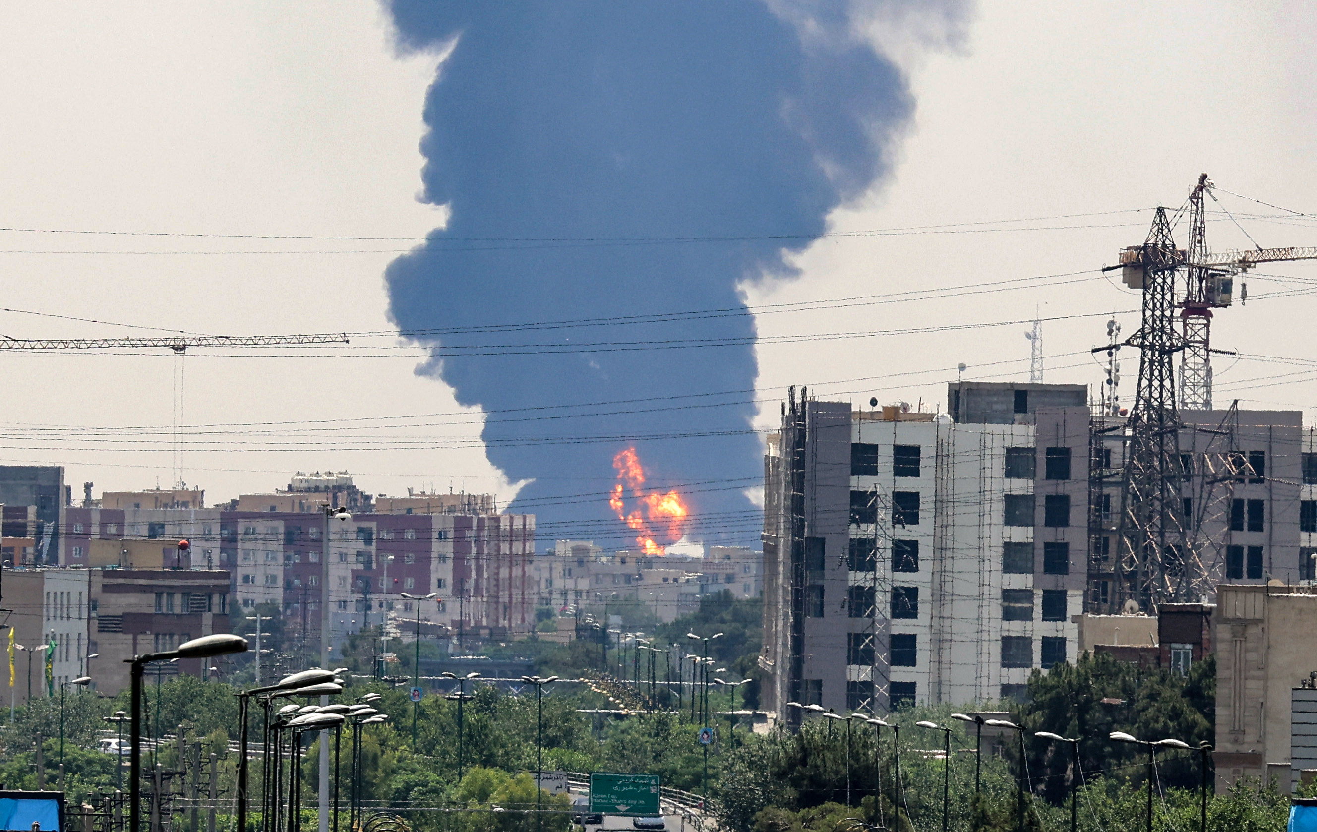 A plume of heavy smoke and fire rise over an oil refinery in southern Tehran