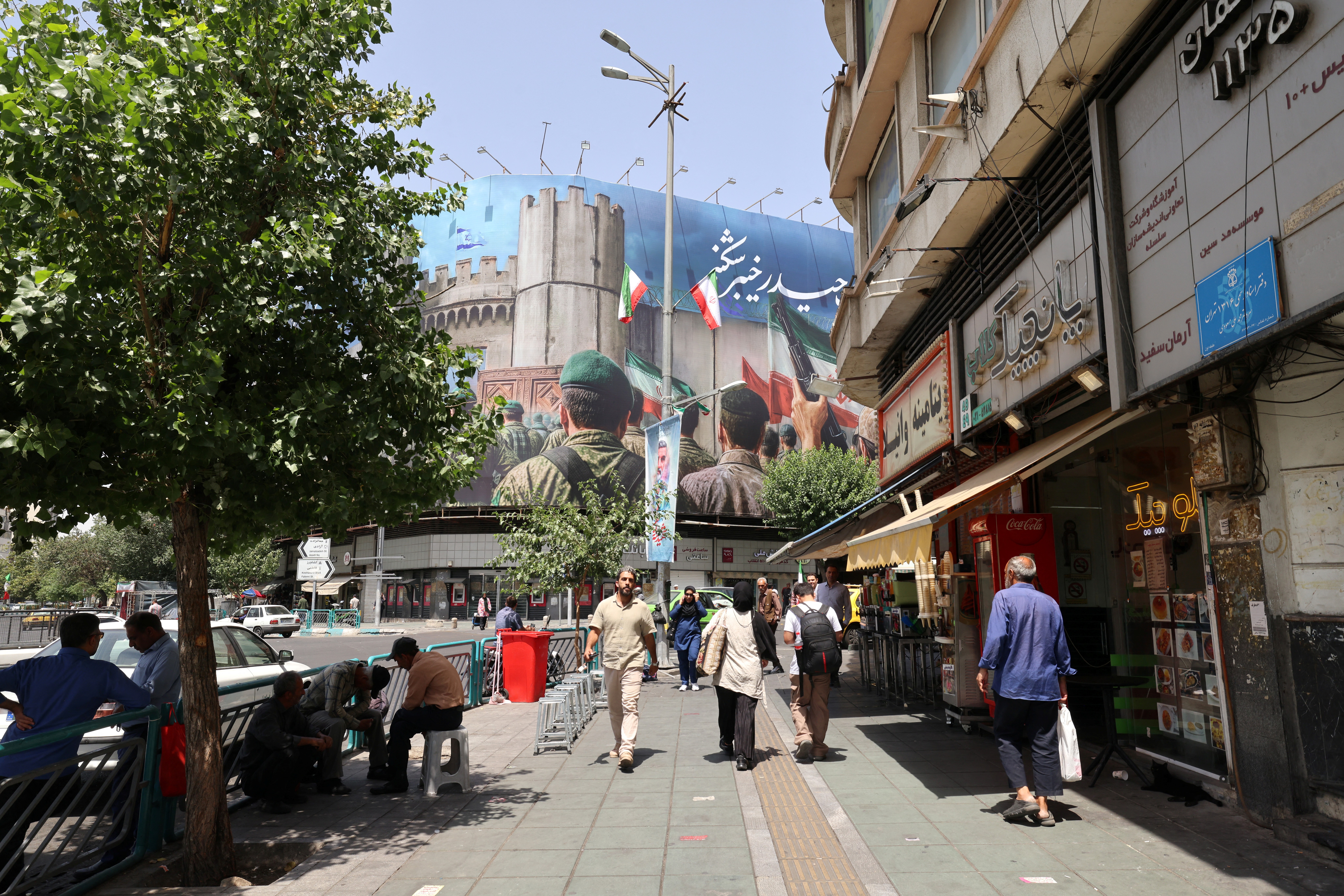 Iranian walk along a street on Enghelab (Revolution) Square, in Tehran on June 24, 2025. Iranian media on June 24, said an overnight Israeli strike on the north of the country killed nine people, ahead of US President's announcement of the start of a ceasefire between Israel and Iran. (Photo by ATTA KENARE / AFP)