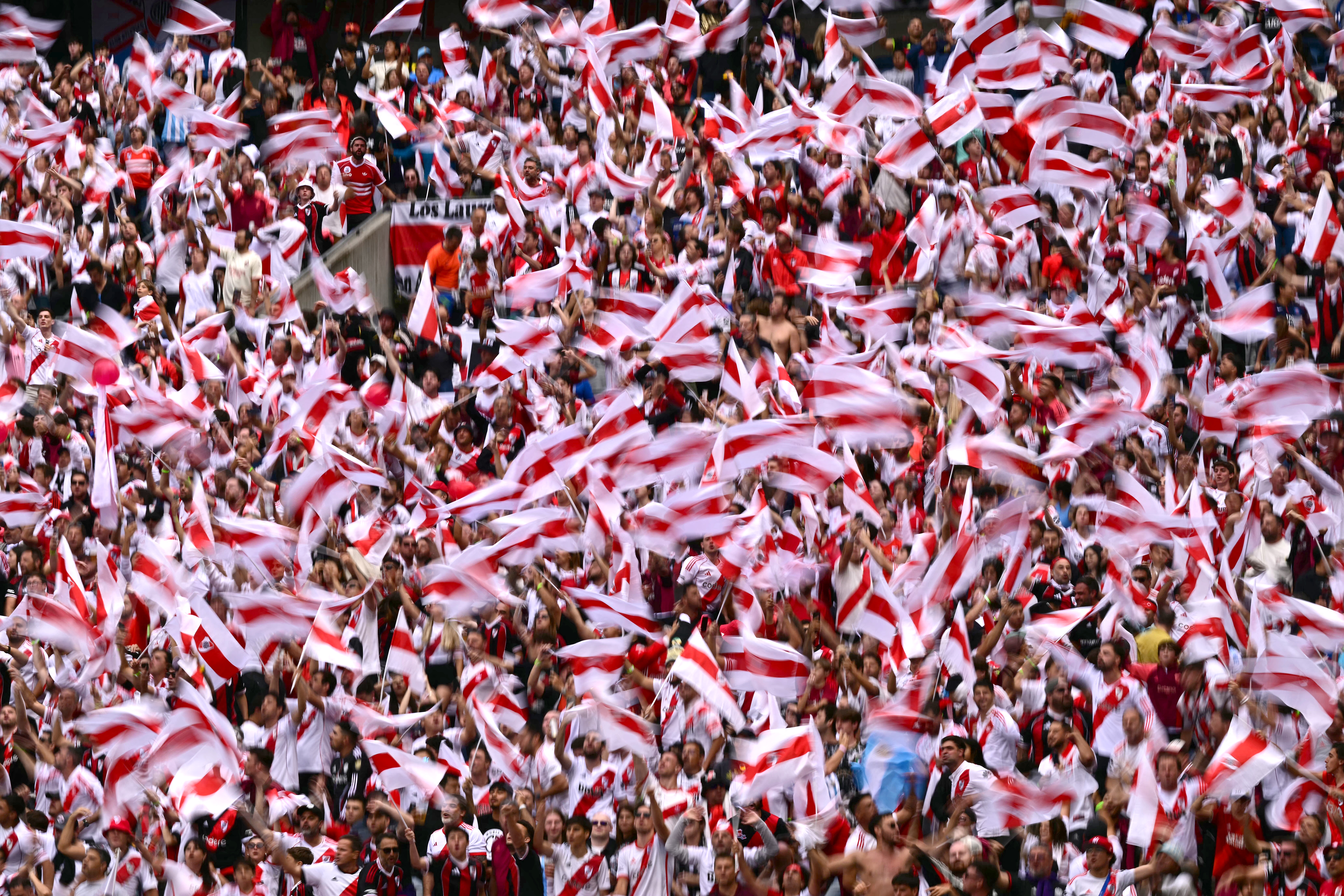 Fans of River Plate wave flags to cheer for their team during the FIFA Club World Cup 2025 Group E football match between Italy's Inter Milan and Argentina's River Plate at the Lumen Field stadium in Seattle on June 23, 2025. (Photo by Pablo PORCIUNCULA / AFP)