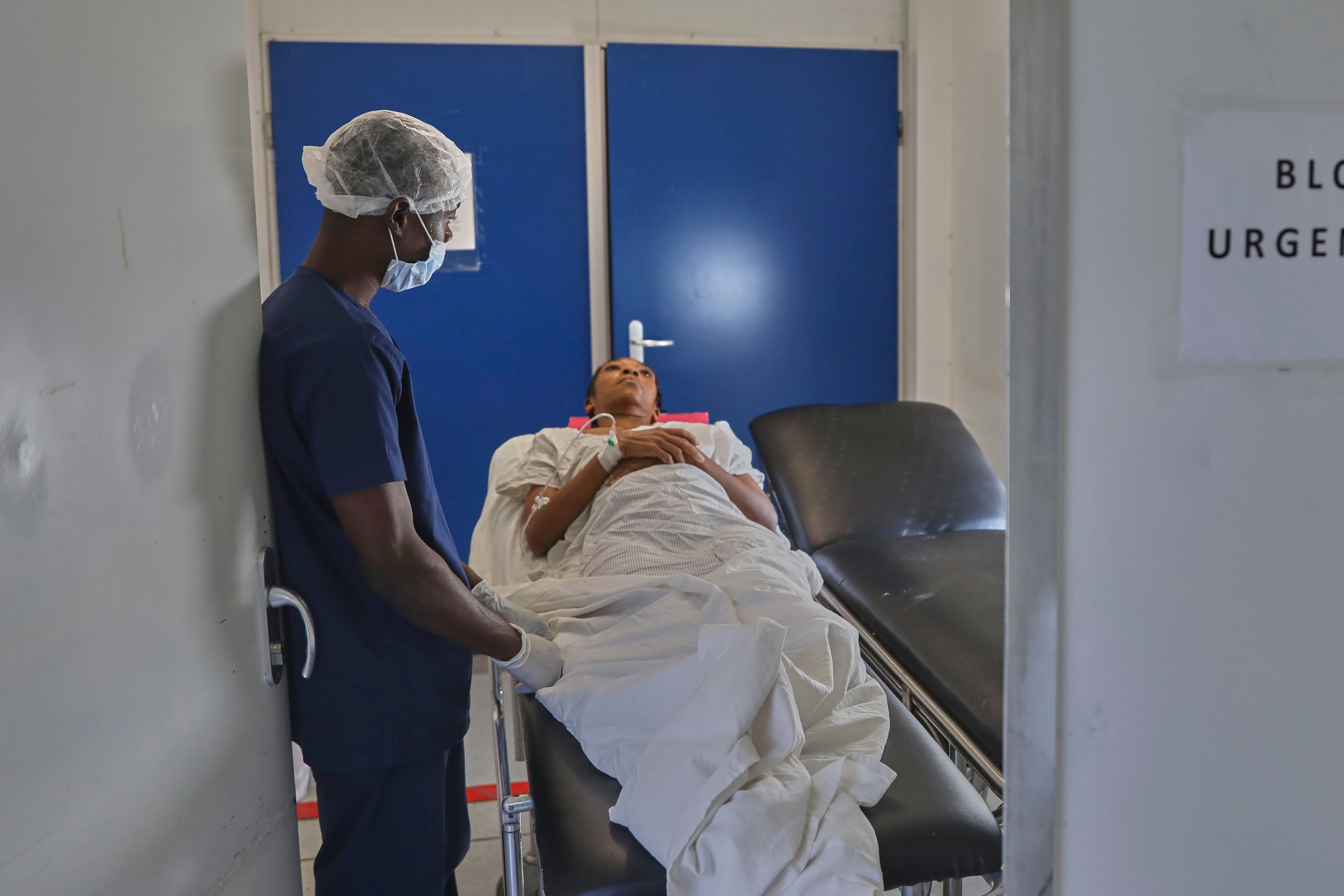 A medical worker transports a patient on a stretcher.