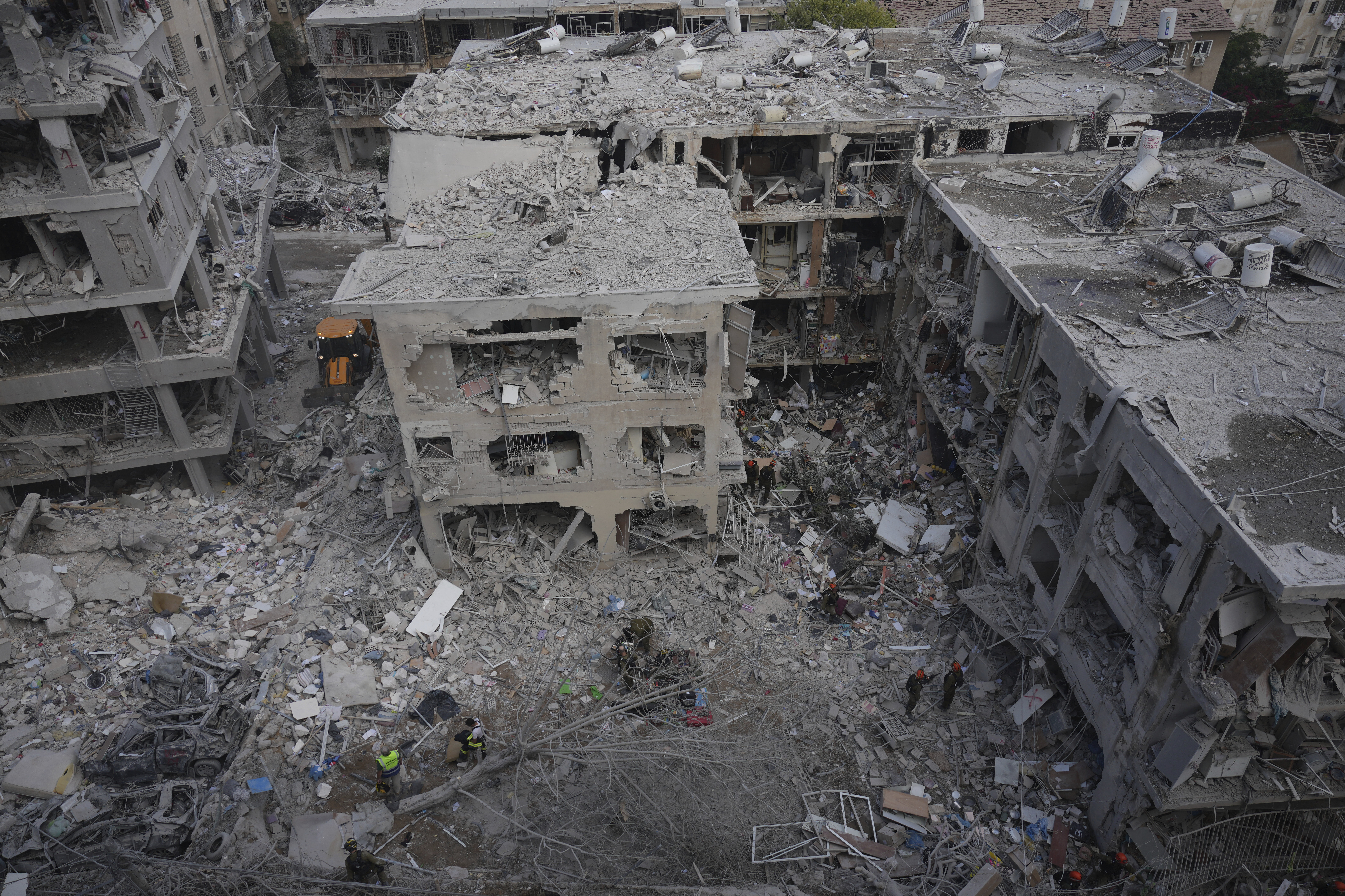 Israeli first responders work in a residential area hit by a missile fired from Iran, in Bat Yam, Israel, Sunday, June 15, 2025.(AP Photo/Ariel Schalit)