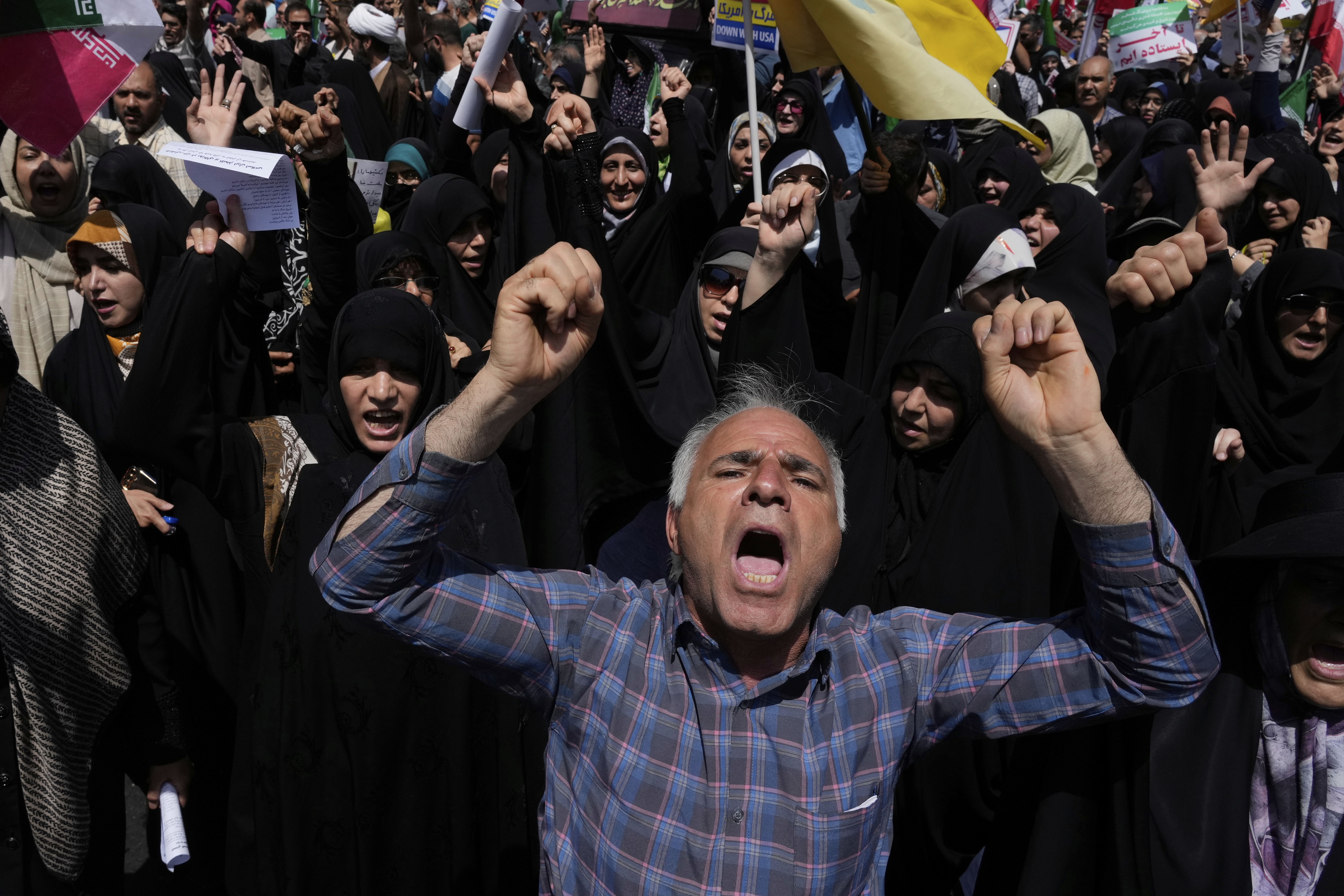 People chant slogans during a protest to condemn Israeli attacks in Tehran, Iran