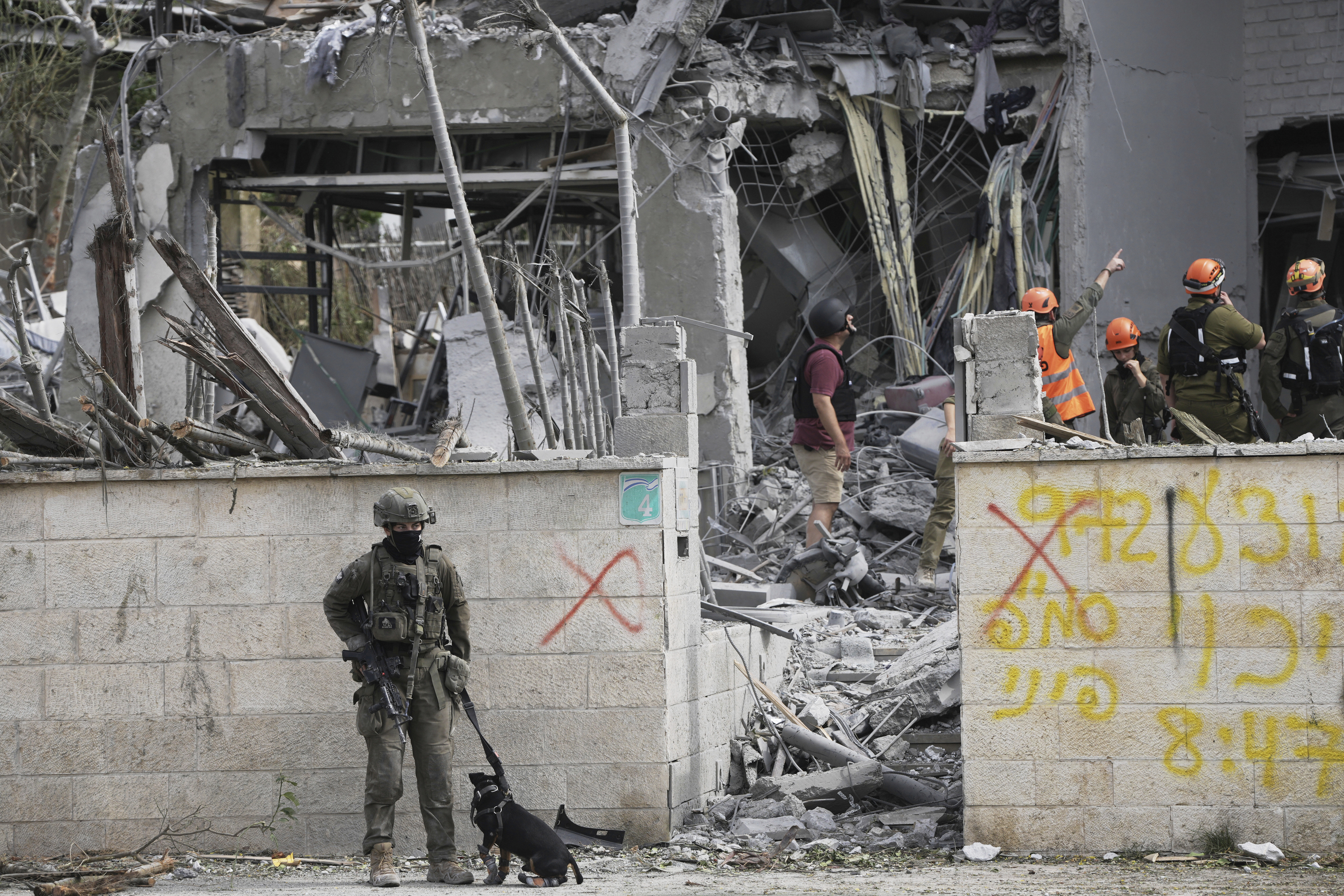 Rescue workers and firefighters survey the site of a direct missile strike launched from Iran in Nes Ziona