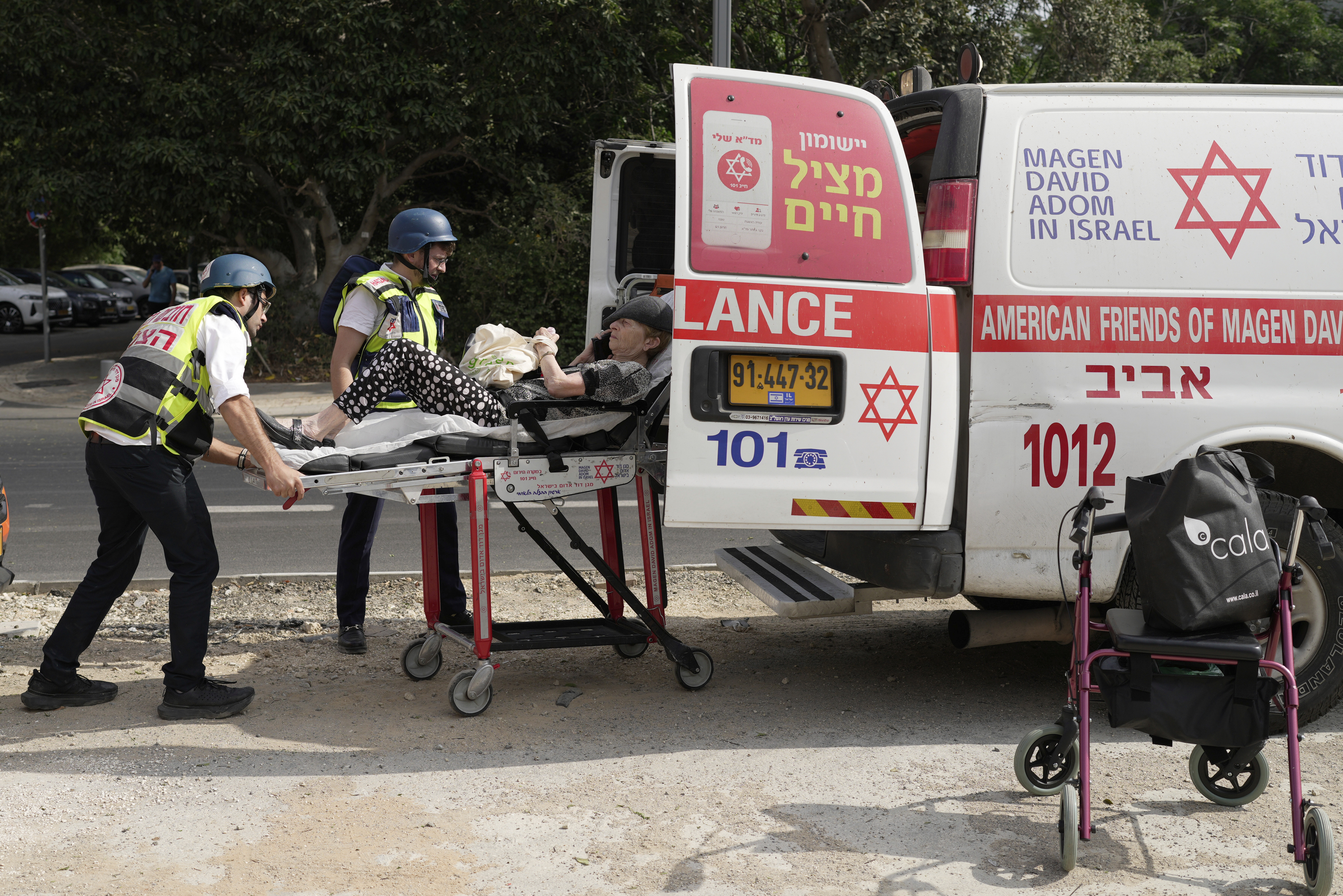 Medics evacuate a woman injured in an Iranian missile strike in Tel Aviv,
