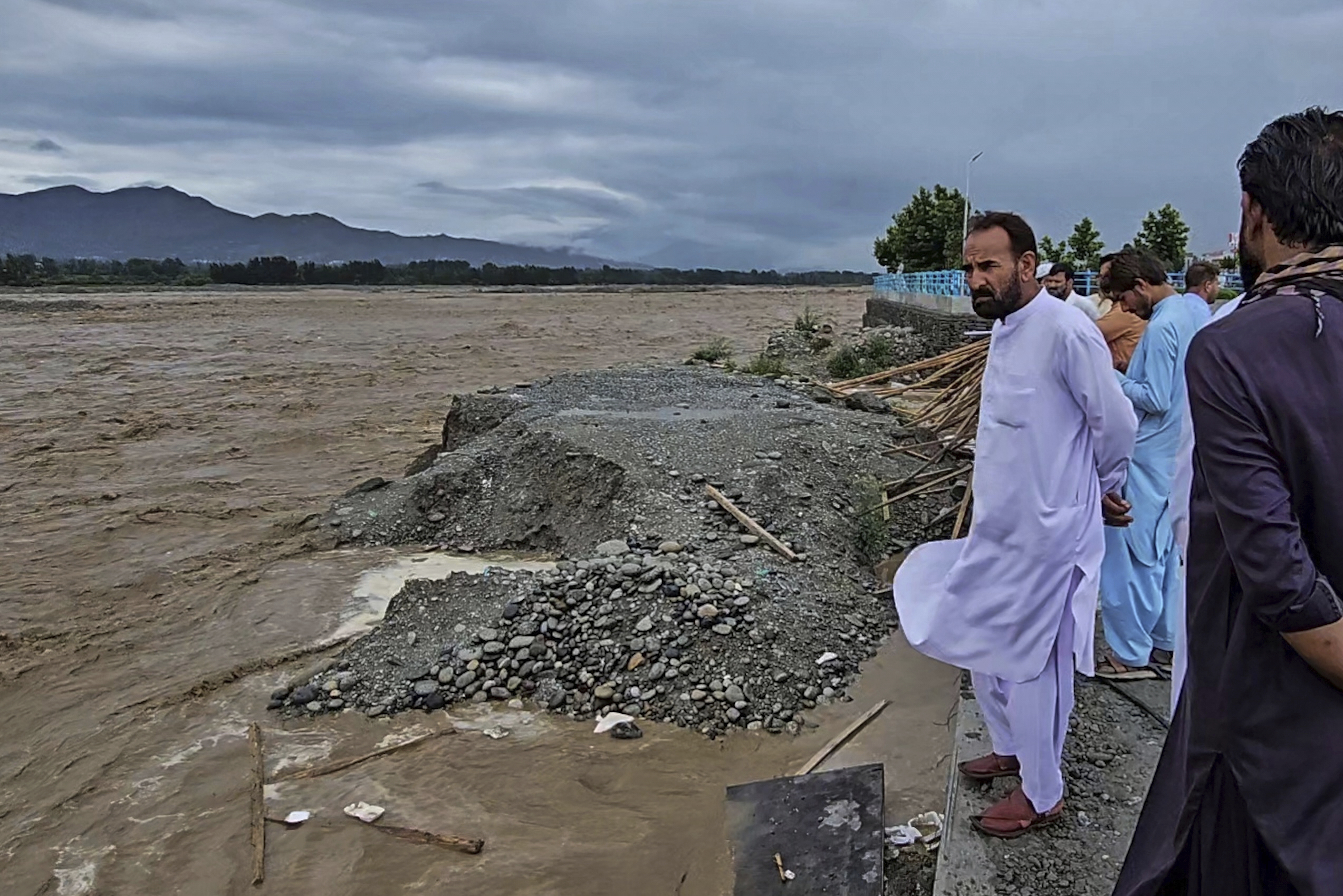 Local residents look to the Swat River, which is overflowing due to pre-monsoon heavy rains in the area, on the outskirts of Mingora, the main town of Pakistan's Swat Valley