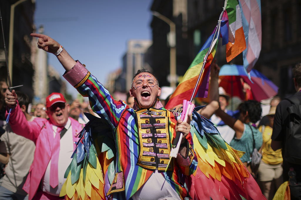 a man wearing bright colours celebrates in a parade