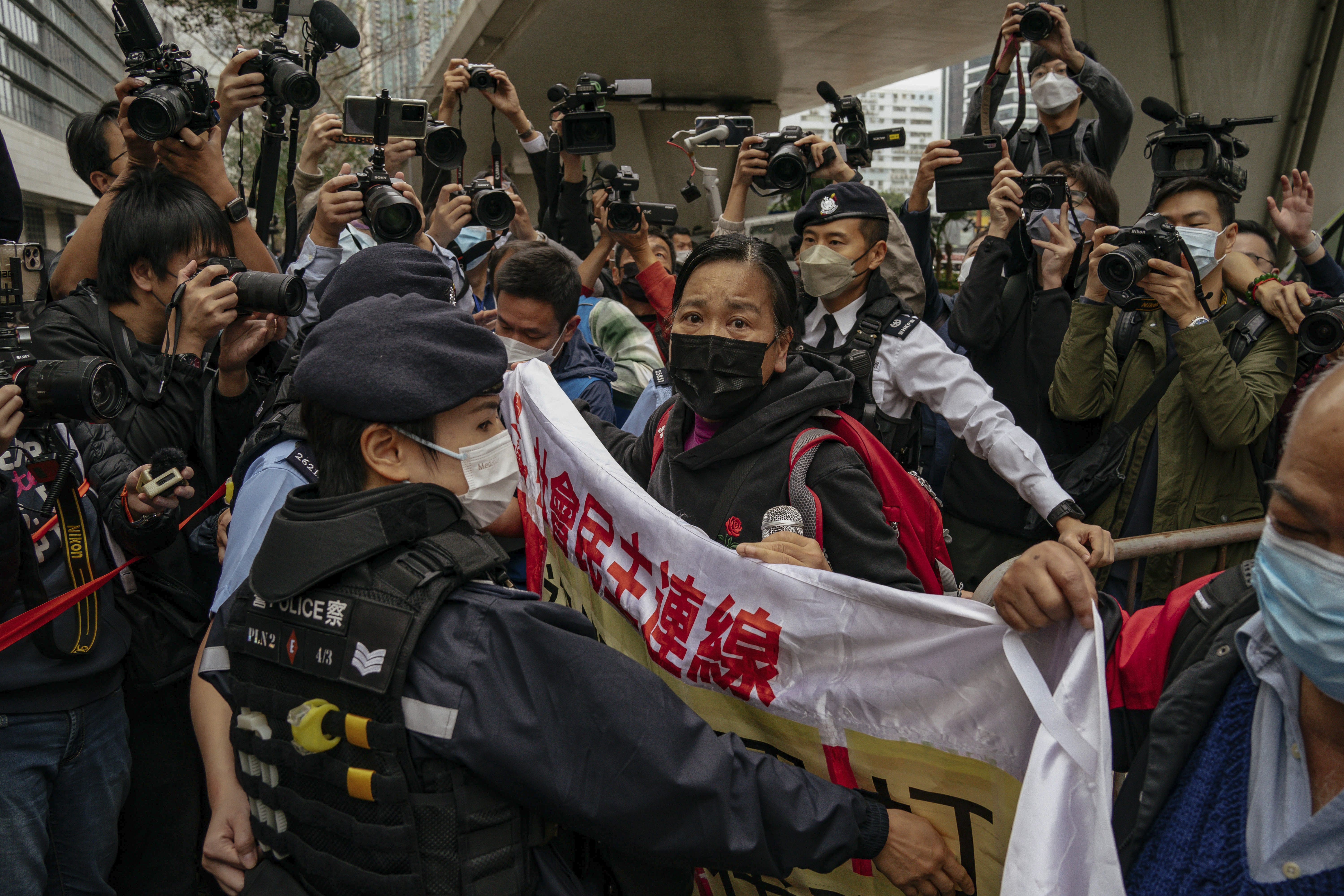 FILE - Photographers take picture of the members of League of Social Democrats scuffling with police outside the West Kowloon Magistrates' Courts ahead of the national security trail for the pro-democracy activists in Hong Kong, on Feb. 6, 2023. (AP Photo/Anthony Kwan, File)