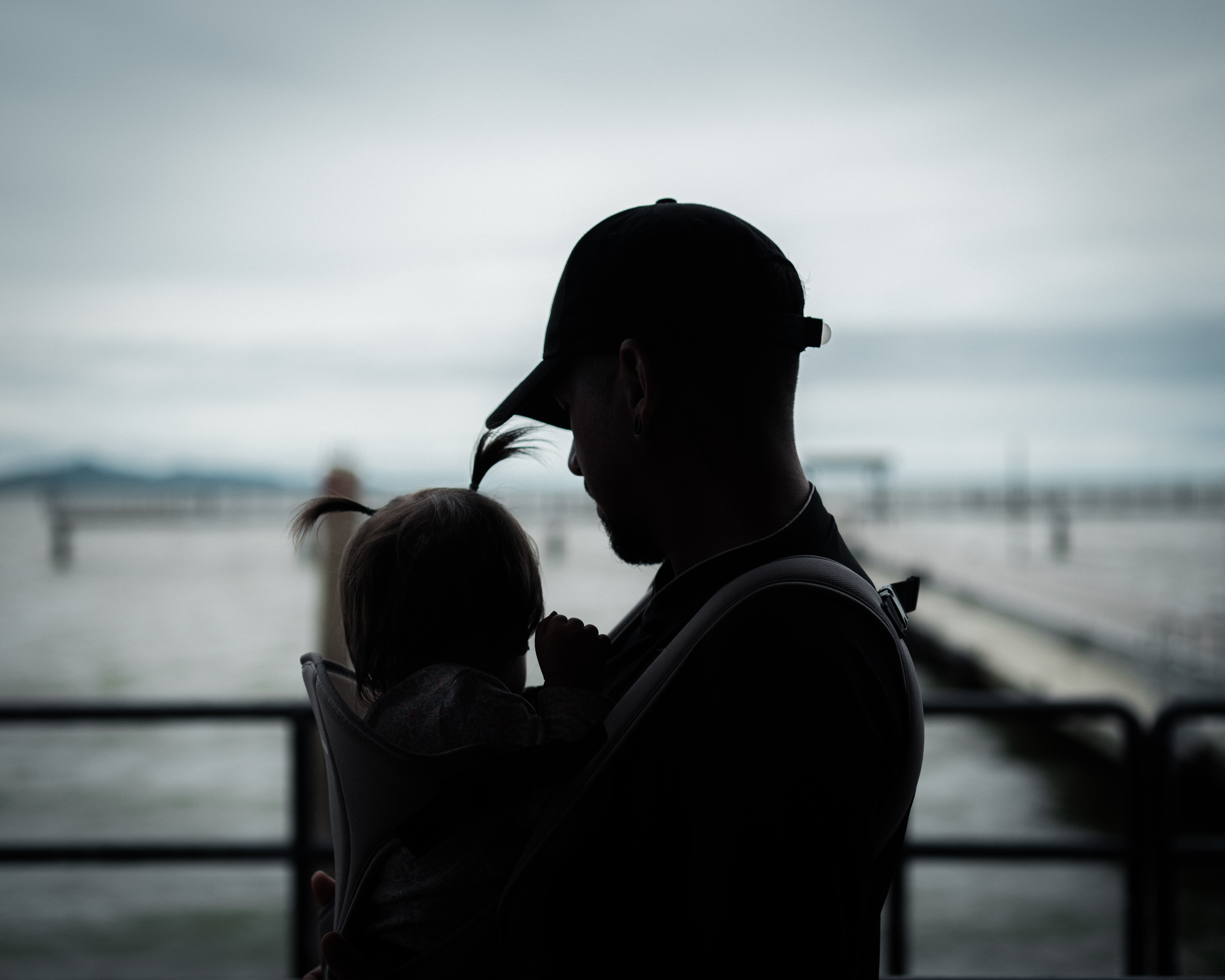 The silhouette of a father and baby against the waters of Necoclí