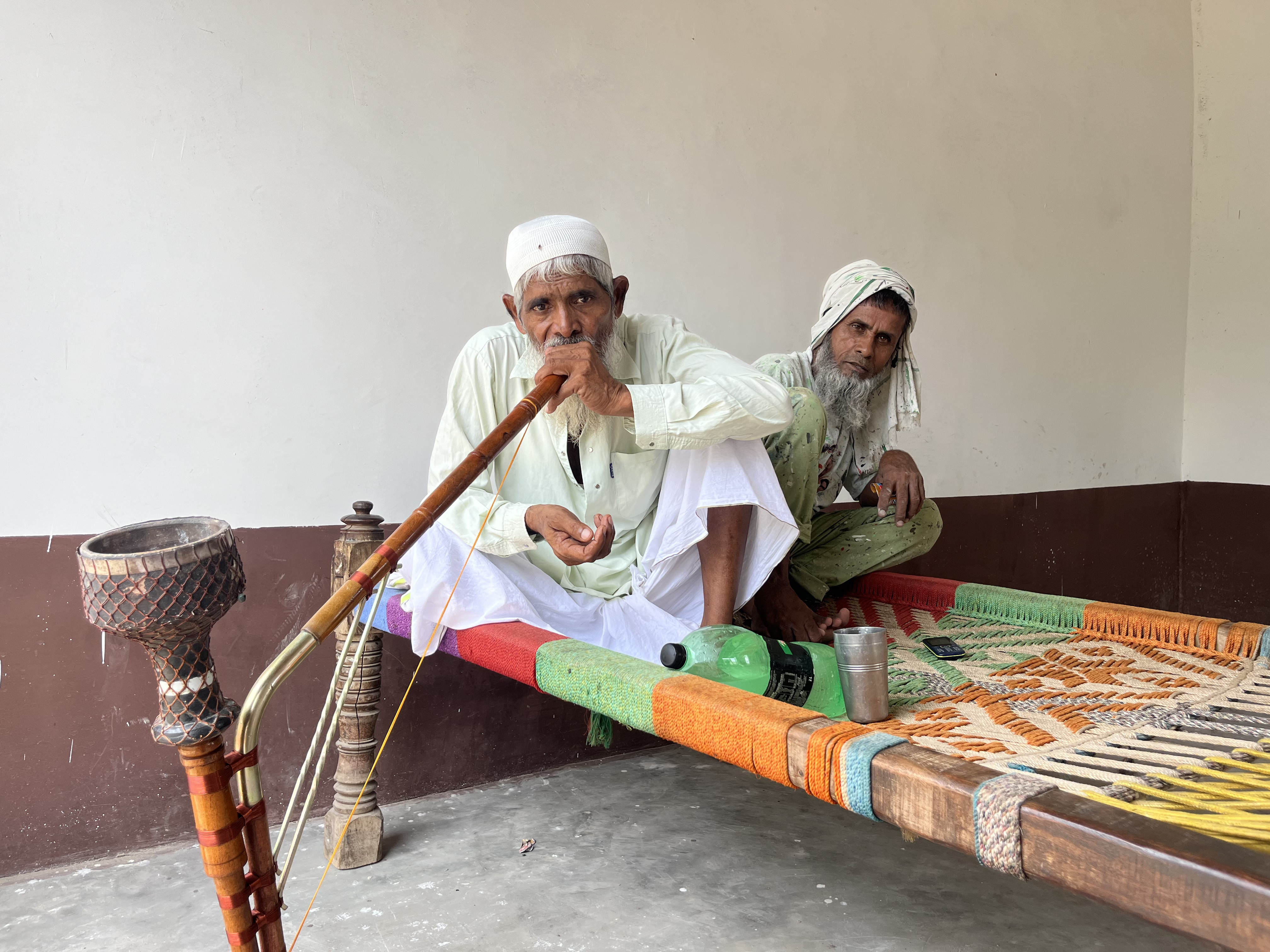Mohammad Noor sitting with his childhood friend, Tajamul Mohammad, at his home in Uttawar, Haryana. [Yashraj Sharma/Al Jazeera]