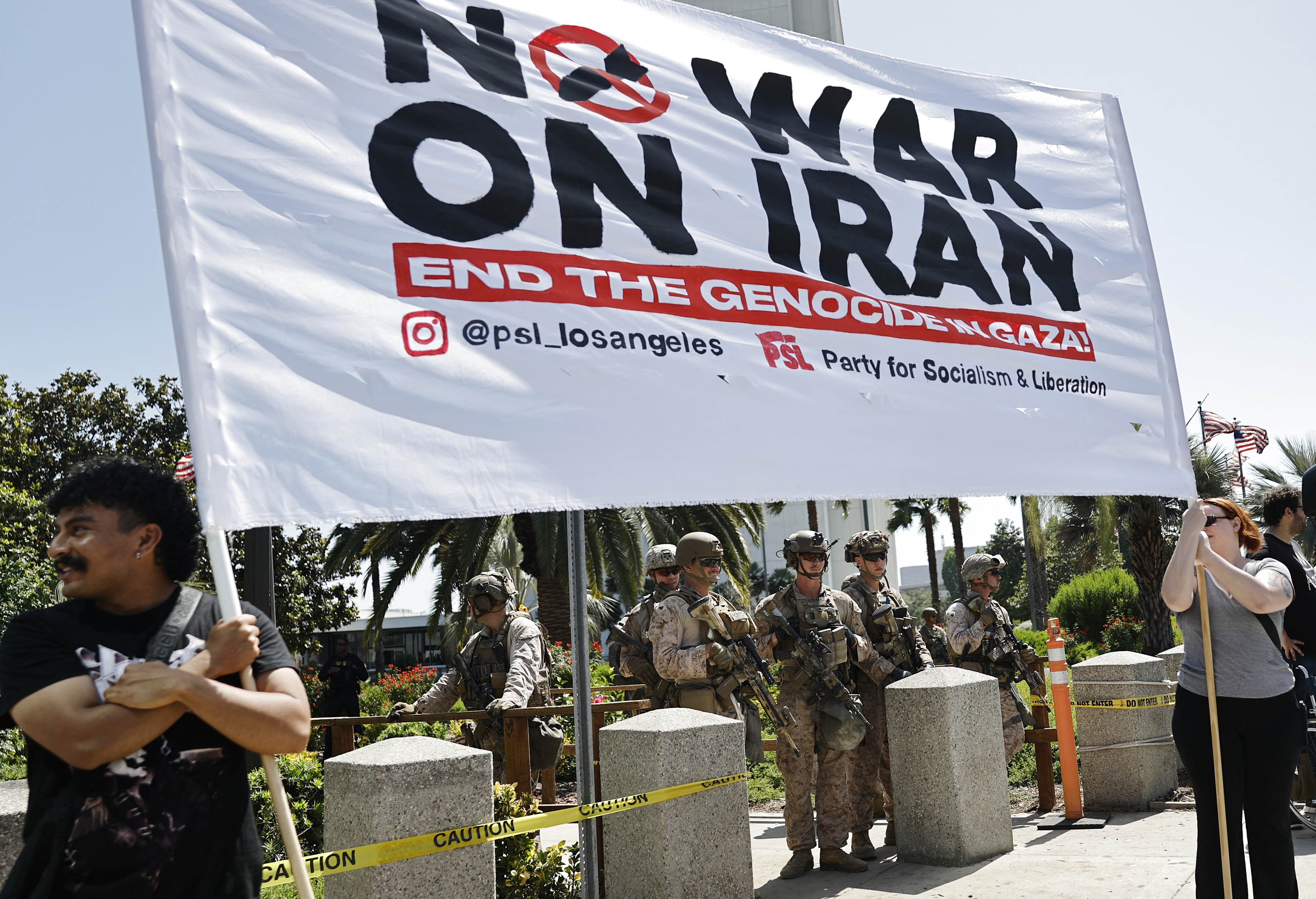LOS ANGELES, CALIFORNIA - JUNE 22: Demonstrators gather near U.S. Marines guarding the Wilshire Federal Building during a rally opposing the United States' strikes on Iran on June 22, 2025 in Los Angeles, California. The U.S. dropped a series of bombs on several alleged nuclear facilities in Iran, joining Israel's ongoing strikes within the country. Iran responded with a barrage of missiles at Israel and promised retaliation against US interests in the region. Mario Tama/Getty Images/AFP (Photo by MARIO TAMA / GETTY IMAGES NORTH AMERICA / Getty Images via AFP)