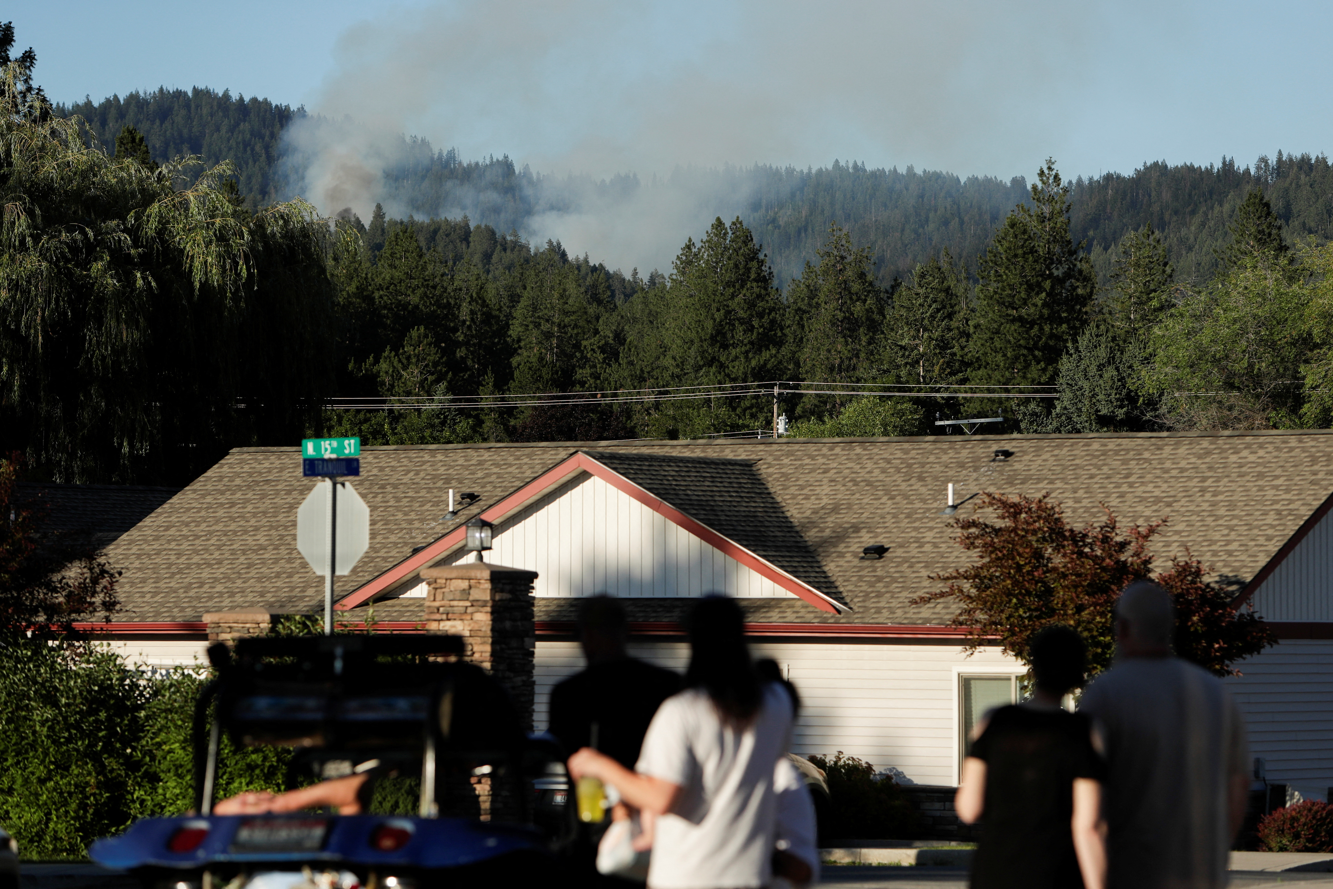 People watch smoke from a fire after multiple firefighters were attacked when responding to a fire in the Canfield Mountain area outside Coeur d'Alene, Idaho, U.S. June 29, 2025. REUTERS/Young Kwak