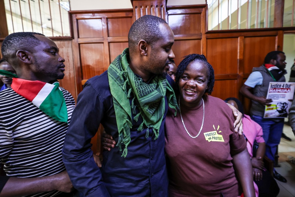 epa12186005 Kenyan activist Boniface Mwangi (C) hugs Gillian Munyao (R), the mother of the late Rex Masai who was killed during the anti-government Gen Z protests in June 2024, after a court hearing of the murder case of her son at the Milimani High Courts in Nairobi, Kenya, 19 June 2025. Among those implicated in the case, which is now marking a year since Rex Masai’s fatal shooting, are police officers Isaiah Muraguri and Benson Kamau. The next hearing of the case will be on 16 July 2025. EPA/DANIEL IRUNGU