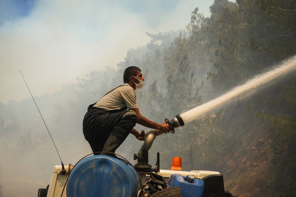 A member of the Syrian emergency services battles the flames at the site of a wildfire in Qastal Maaf area of Latakia countryside