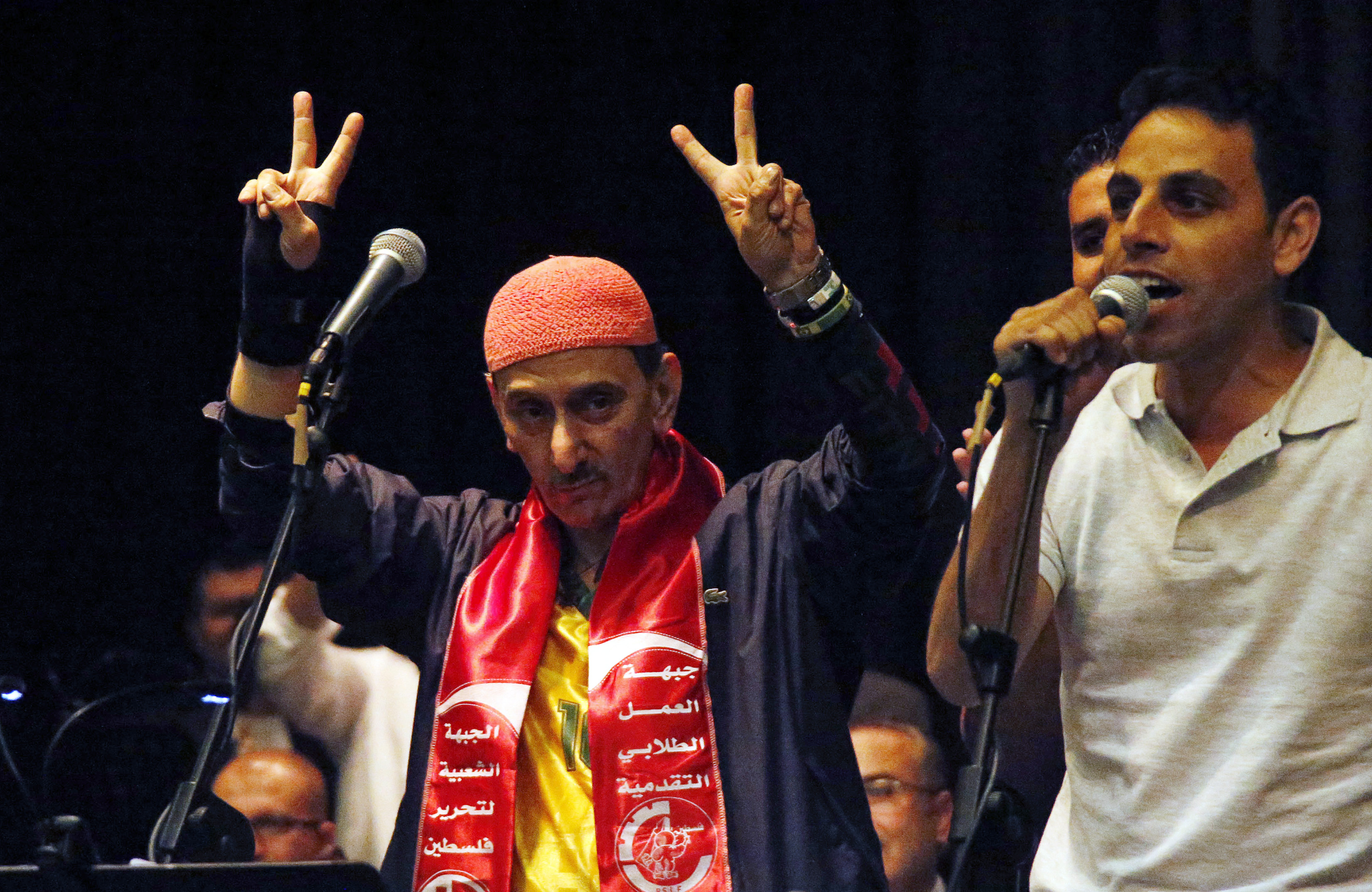 Lebanese musician and composer Ziad Rahbani gestures while wearing a scarf of the Popular Front for the Liberation of Palestine, during a concert at the port-city of Sidon, southern Lebanon October 9, 2014. Palestinian students (R) coming from Gaza offered him the scarf. REUTERS/Ali Hashisho (LEBANON - Tags: ENTERTAINMENT)