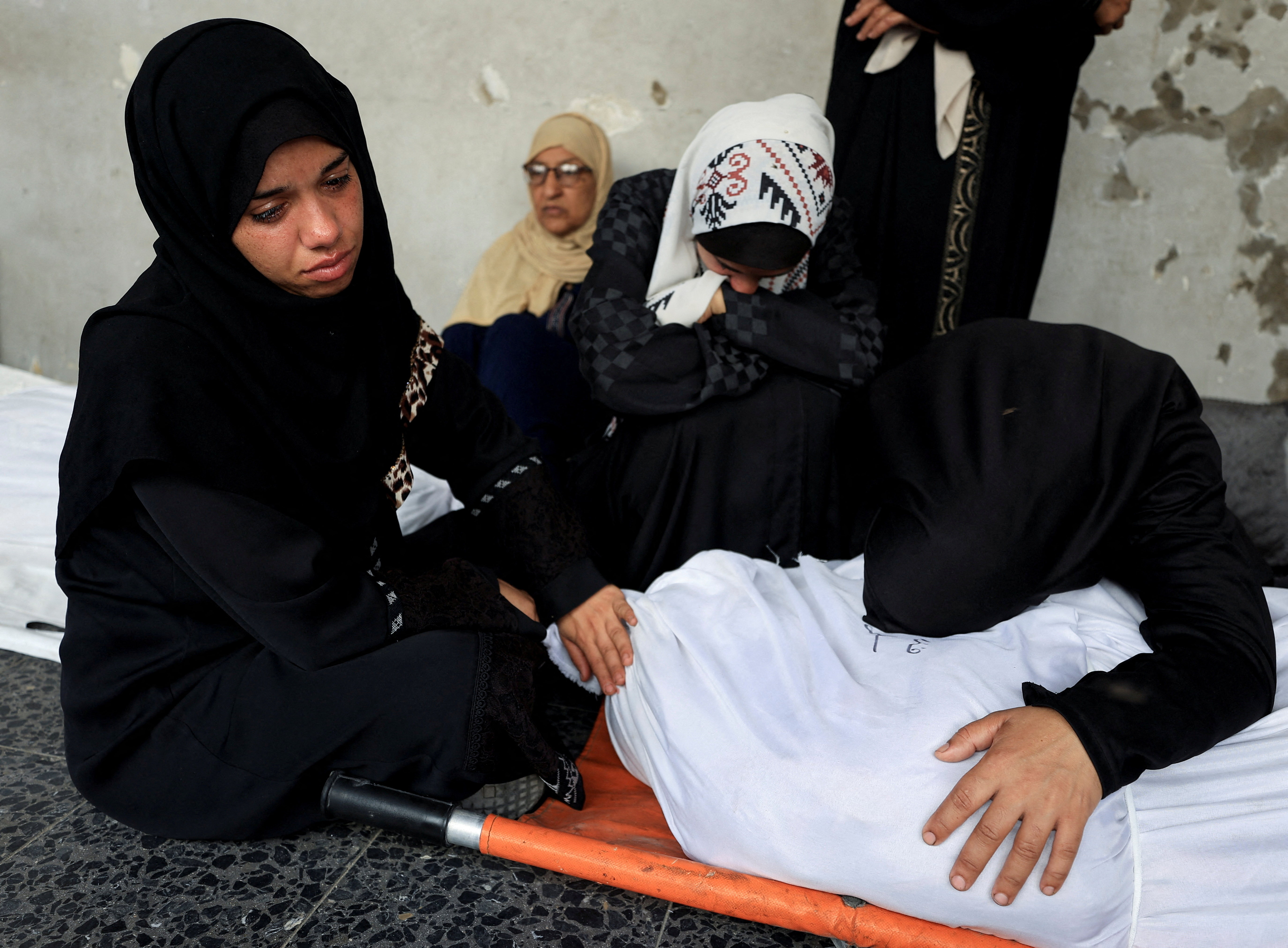 A mourner reacts over a body at the funeral of Palestinians killed in an overnight Israeli air strike on an UNRWA school sheltering displaced people, according to Gaza’s health ministry, at Al-Ahli Arab Hospital in Gaza City, July 5, 2025.