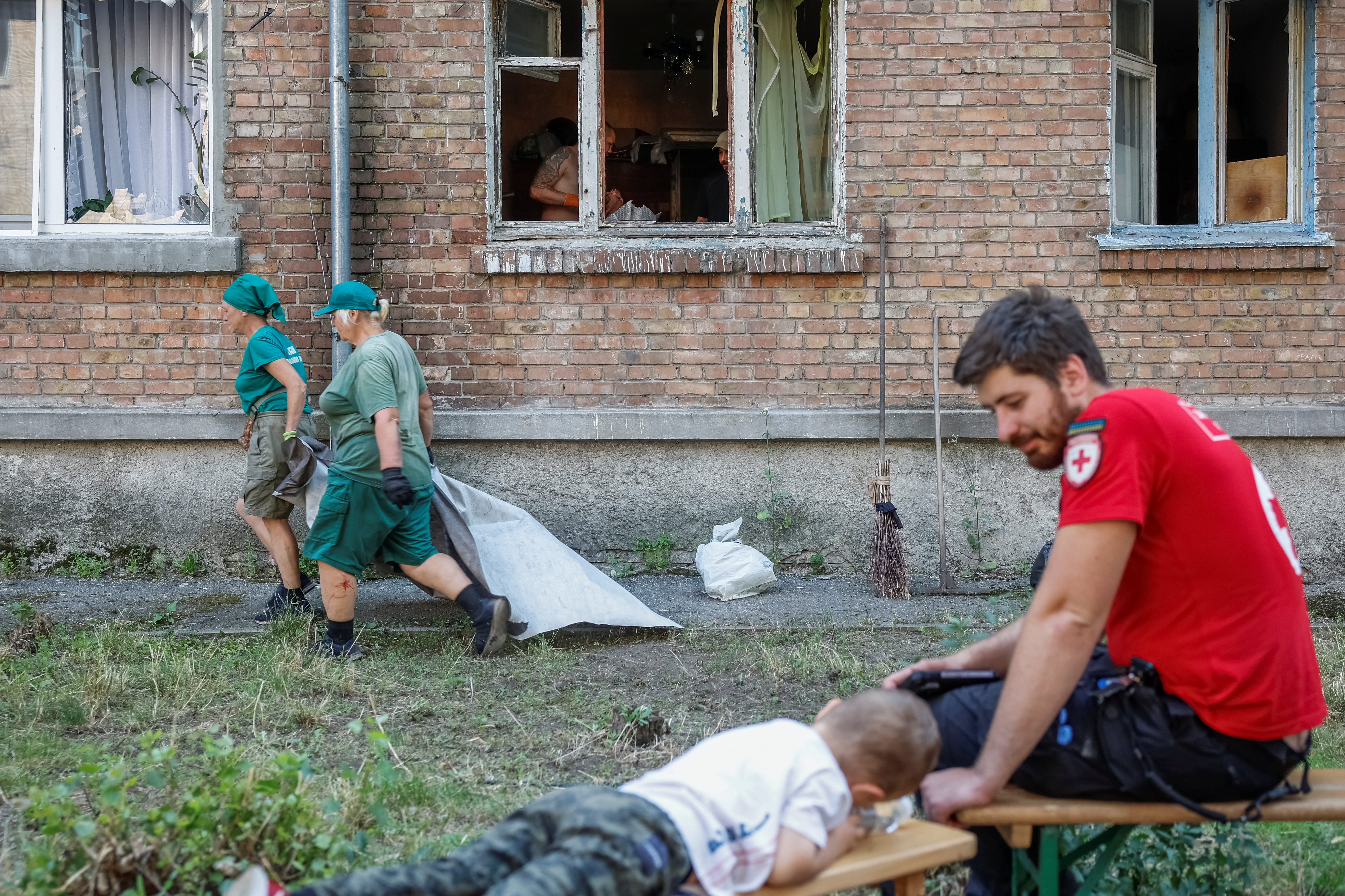 A boy plays on a bench near a residential building, which was damaged during Russian drone and missile strikes, while his parents clean up in their apartment, amid Russia’s attack on Ukraine, in Kyiv, Ukraine July 10, 2025. REUTERS/Alina Smutko TPX IMAGES OF THE DAY