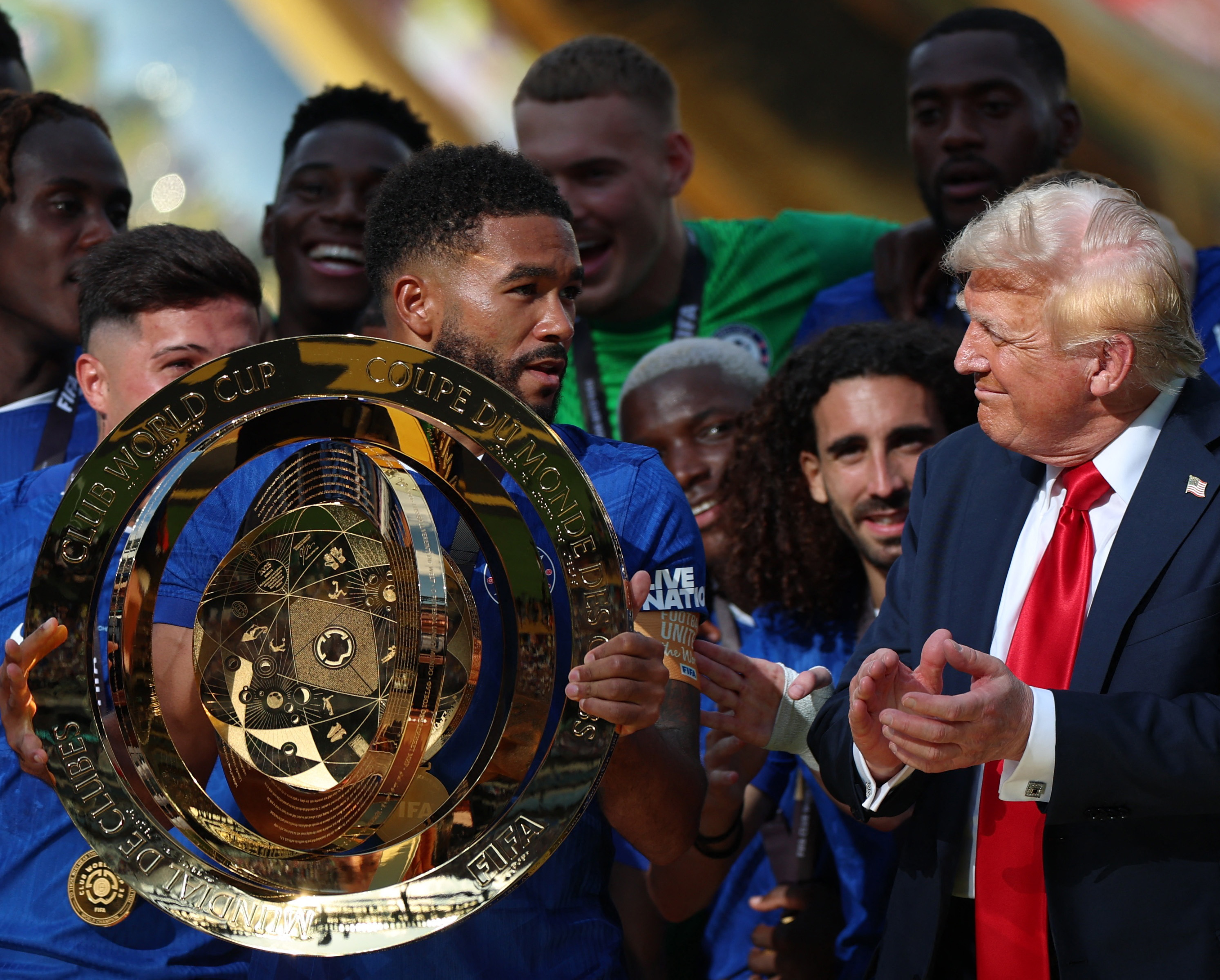 Football - FIFA Club World Cup - Final - Chelsea v Paris St Germain - MetLife Stadium, East Rutherford, New Jersey, U.S. - July 13, 2025 Chelsea's Reece James lifts the trophy as he celebrates with teammates after winning the FIFA Club World Cup as President Donald Trump applauds