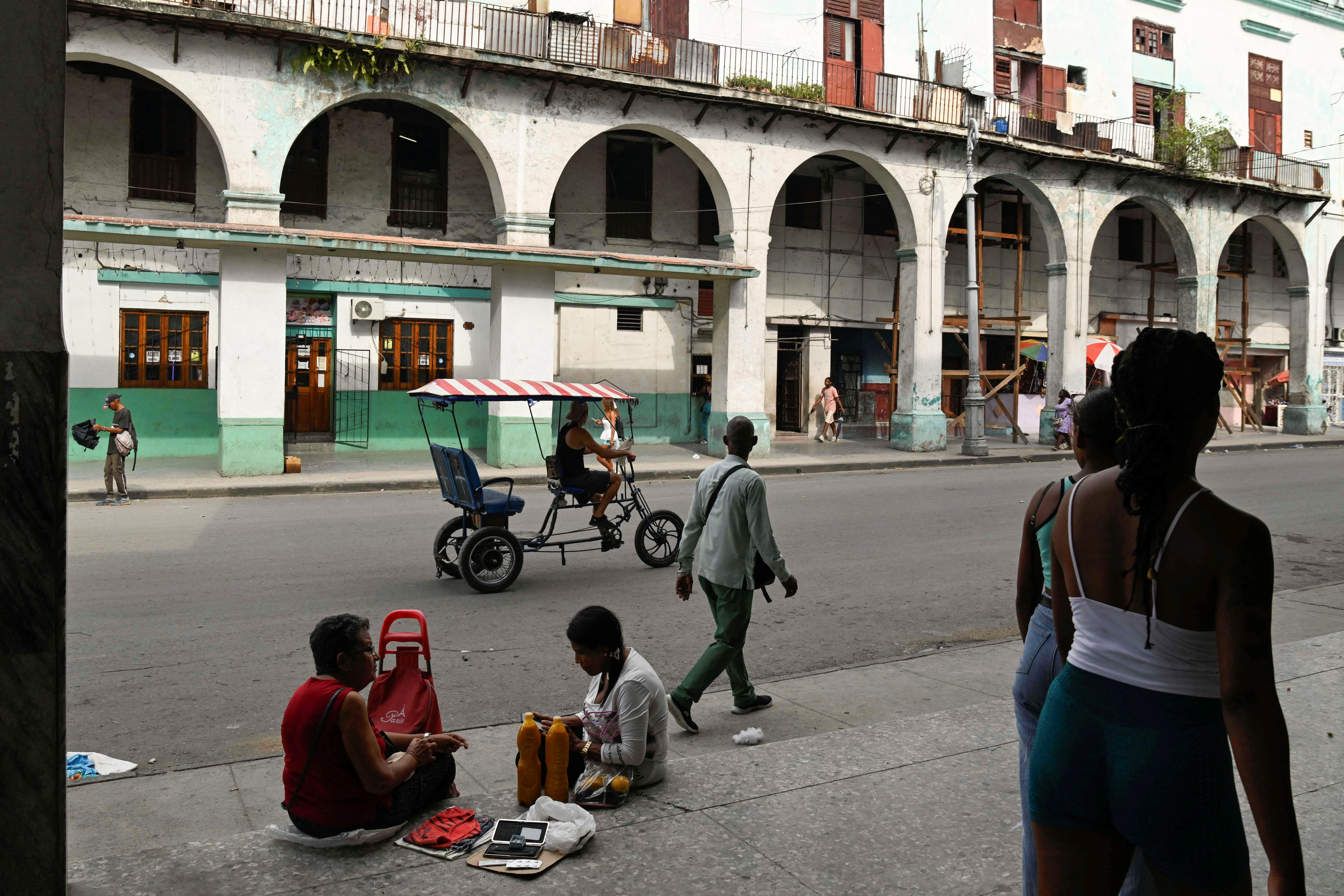people sit in a street with old buildings