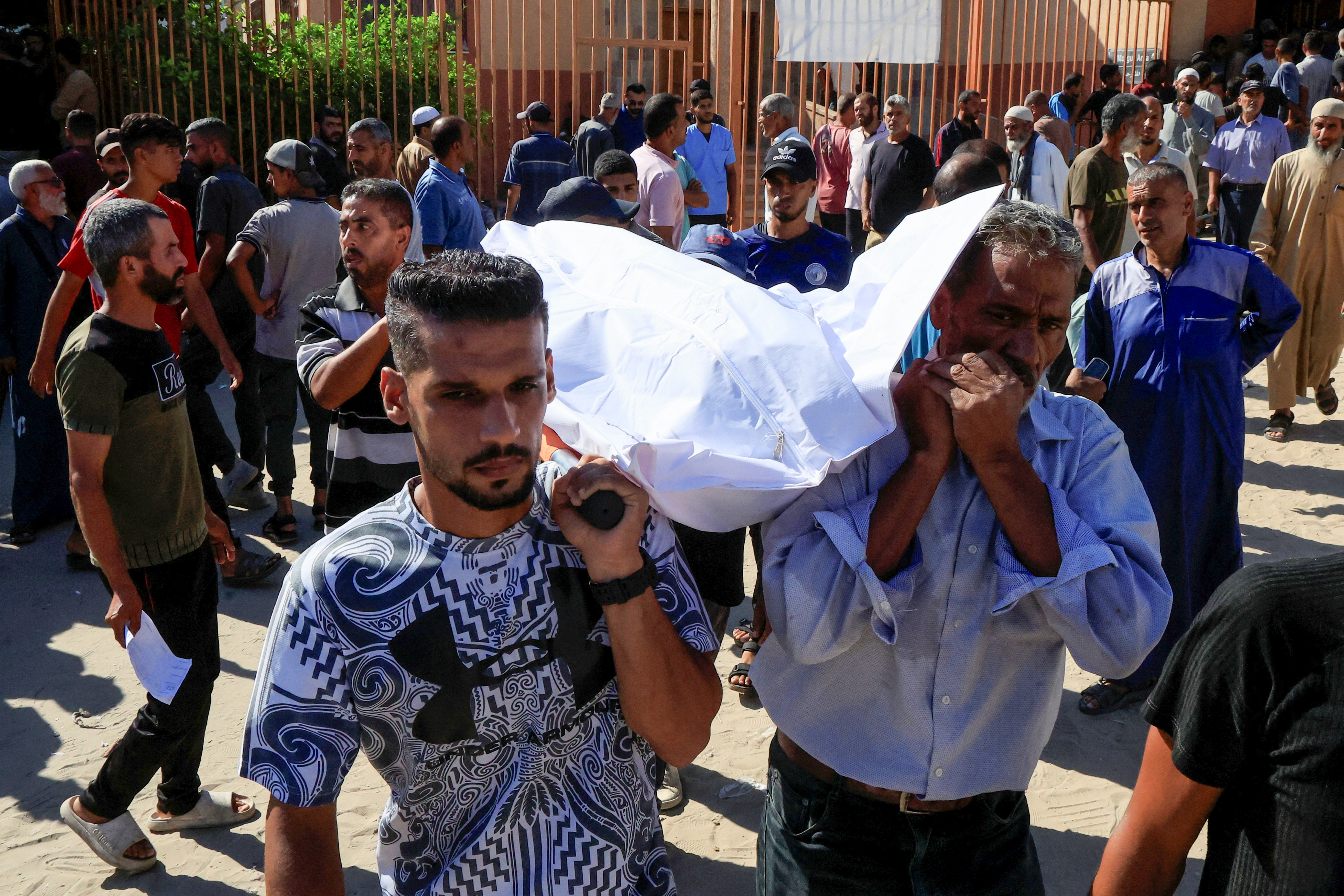 People carry a body as they mourn Palestinians who were killed.