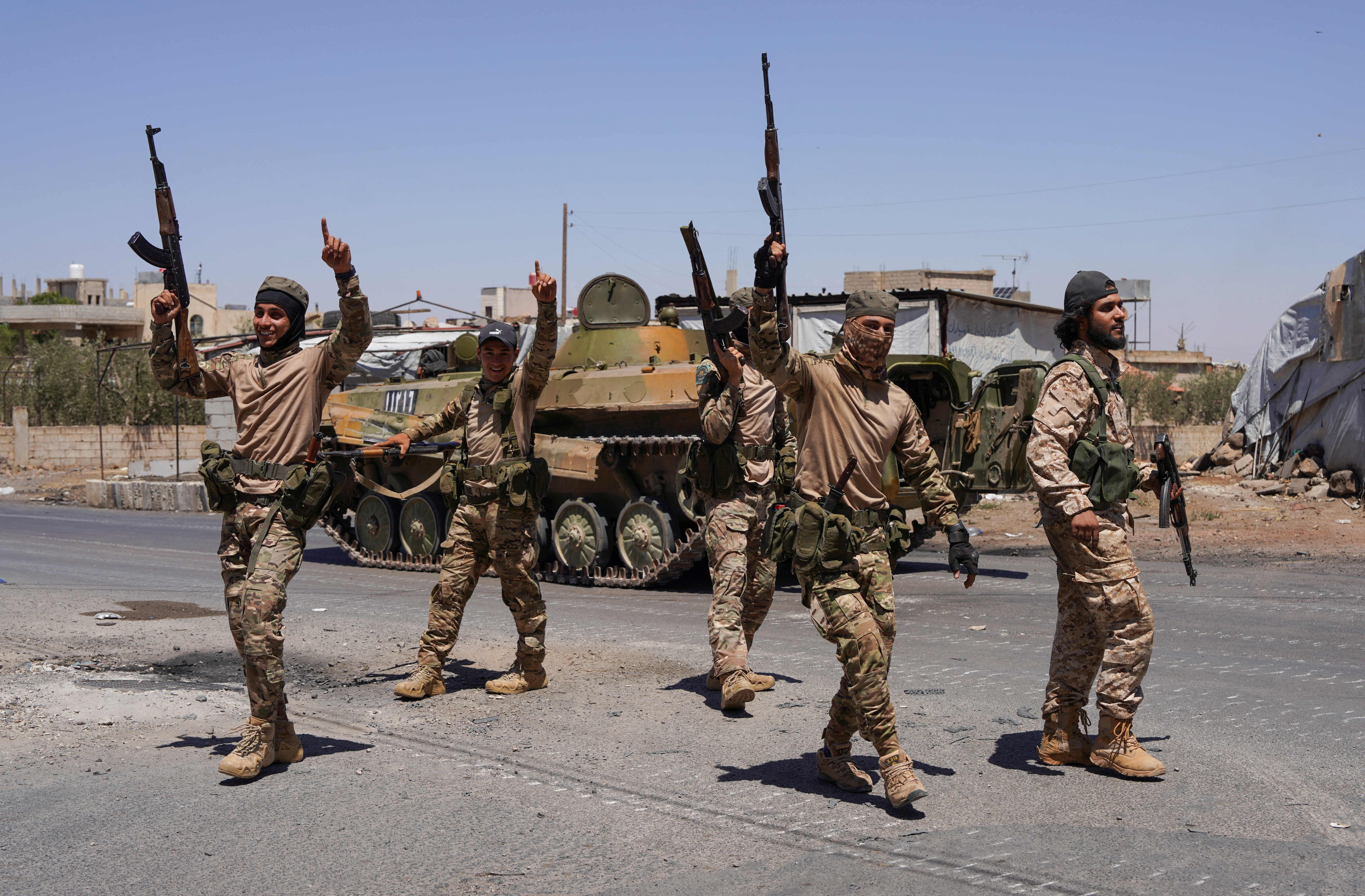 Syrian security forces walk along a street in Suwayda.