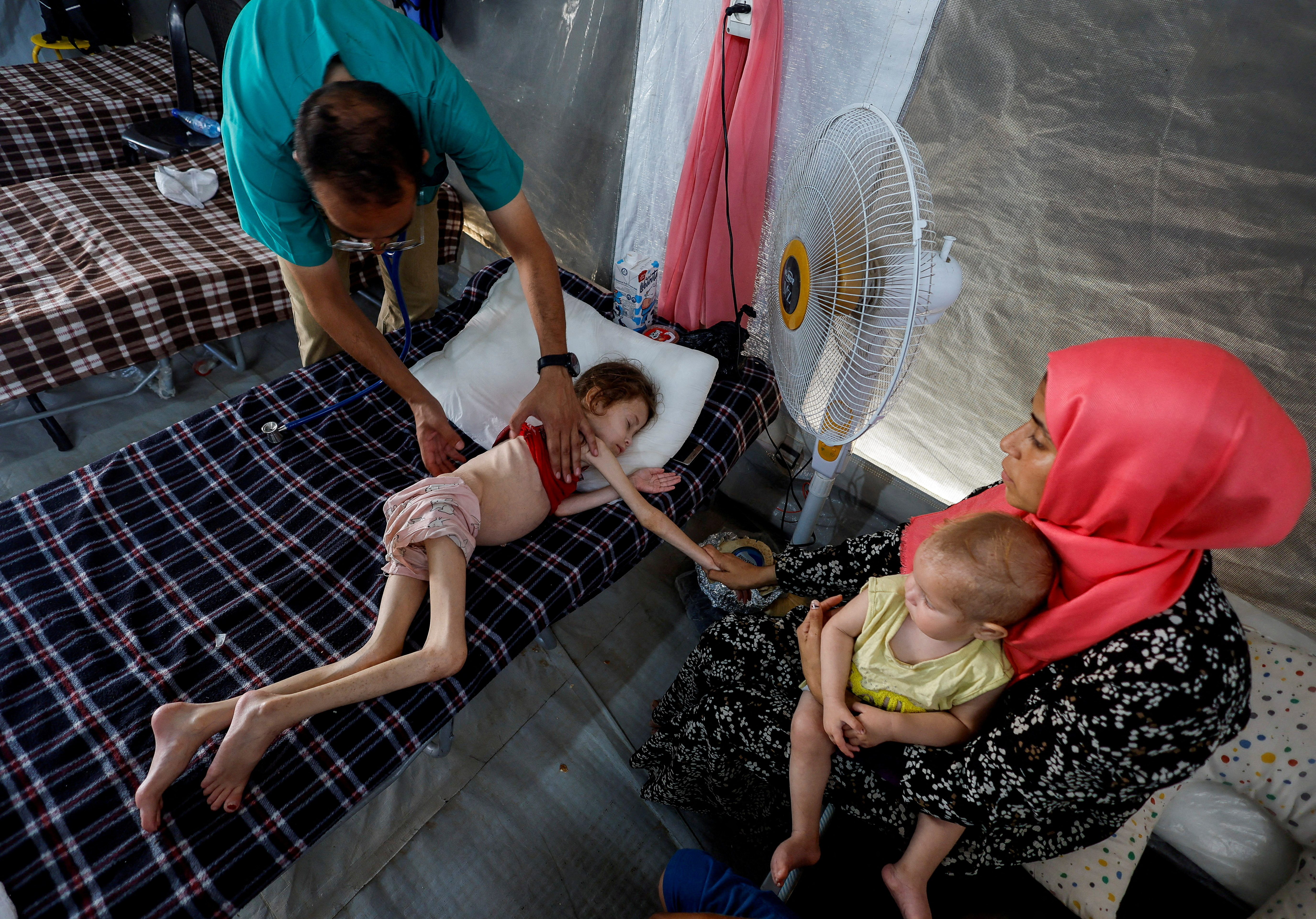 A doctor checks Jana Ayad, a malnourished Palestinian girl, as she receives treatment
