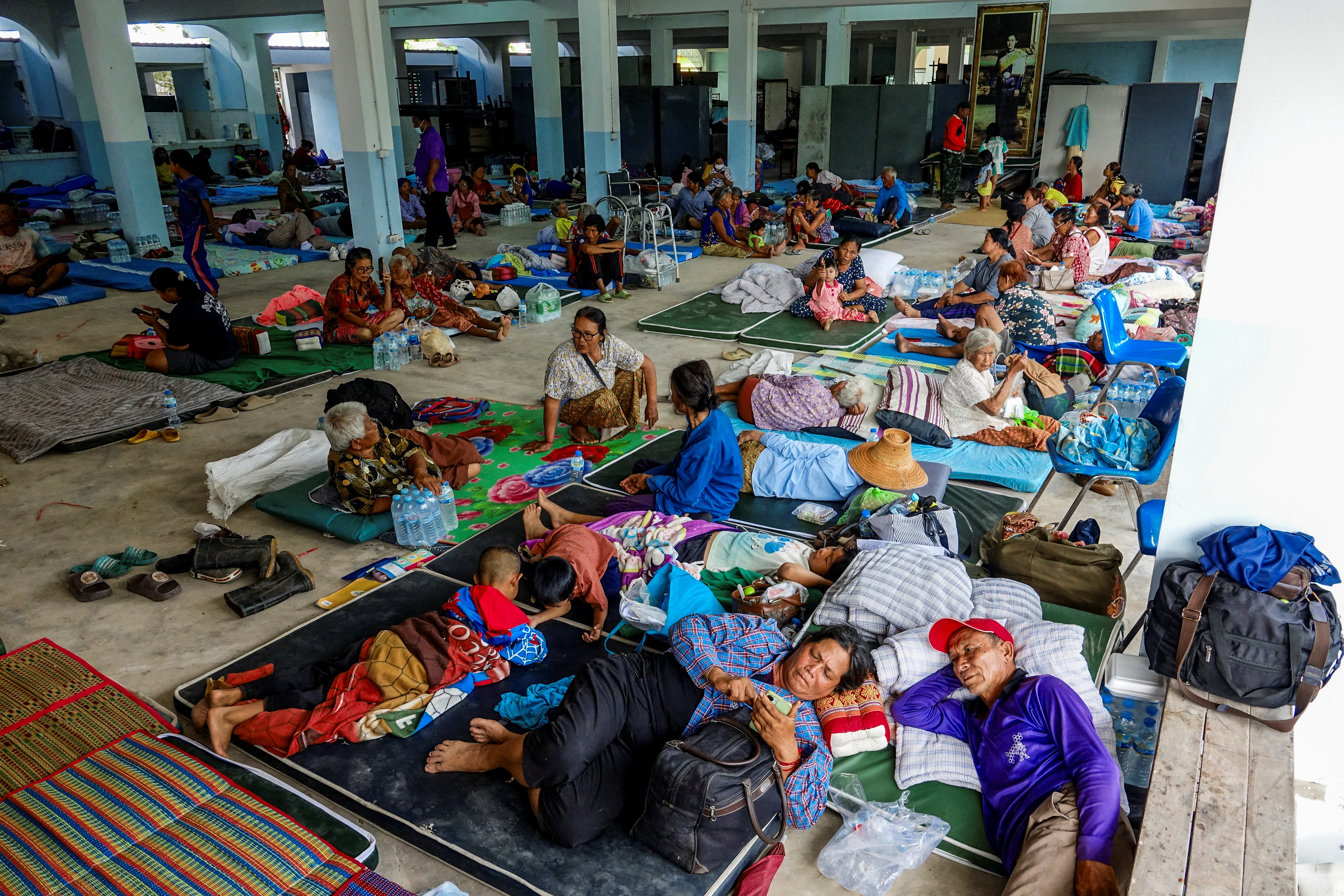 People rest at a shelter amid the clashes between Thailand and Cambodia border, in Surin province