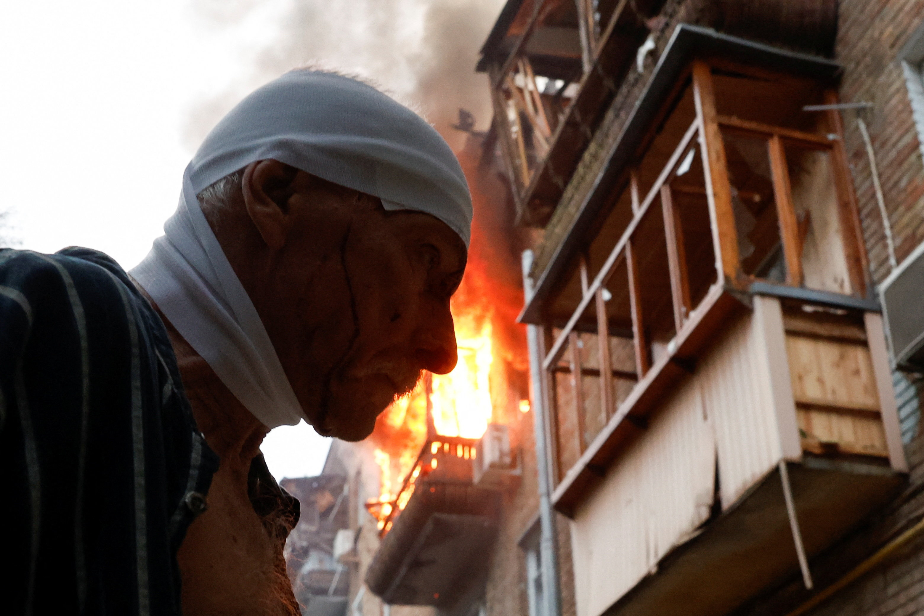An injured resident stands outside his damaged apartment building hit during Russian missile and drone strikes, amid Russia's attack on Ukraine, in Kyiv, Ukraine July 31, 2025. REUTERS/Thomas Peter