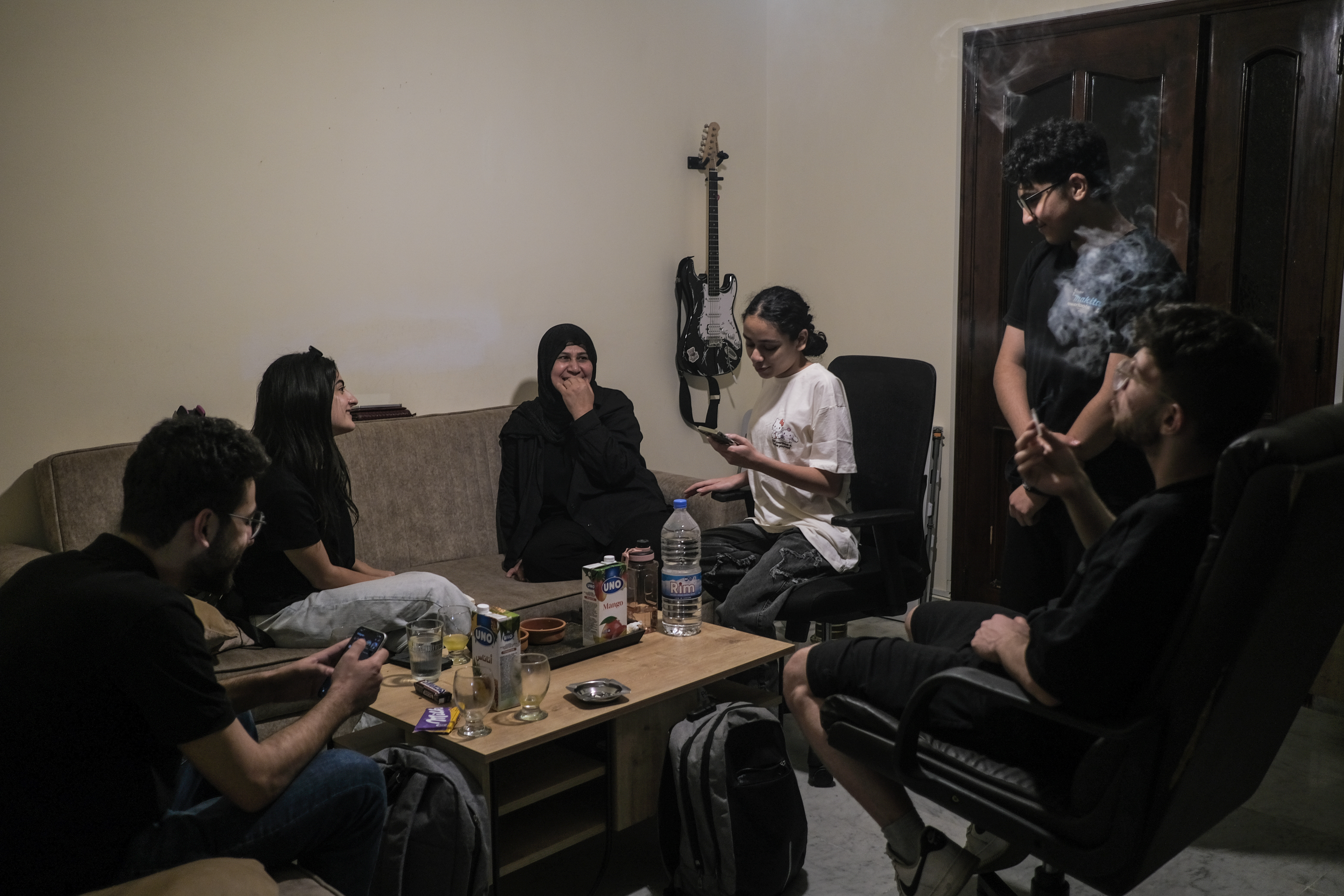 Iman Kandeel and some members of her family gather in their living room in Hadath, Beirut, a home they are contemplating leaving if the war between Israel and Lebanon escalates again [João Sousa/Al Jazeera]