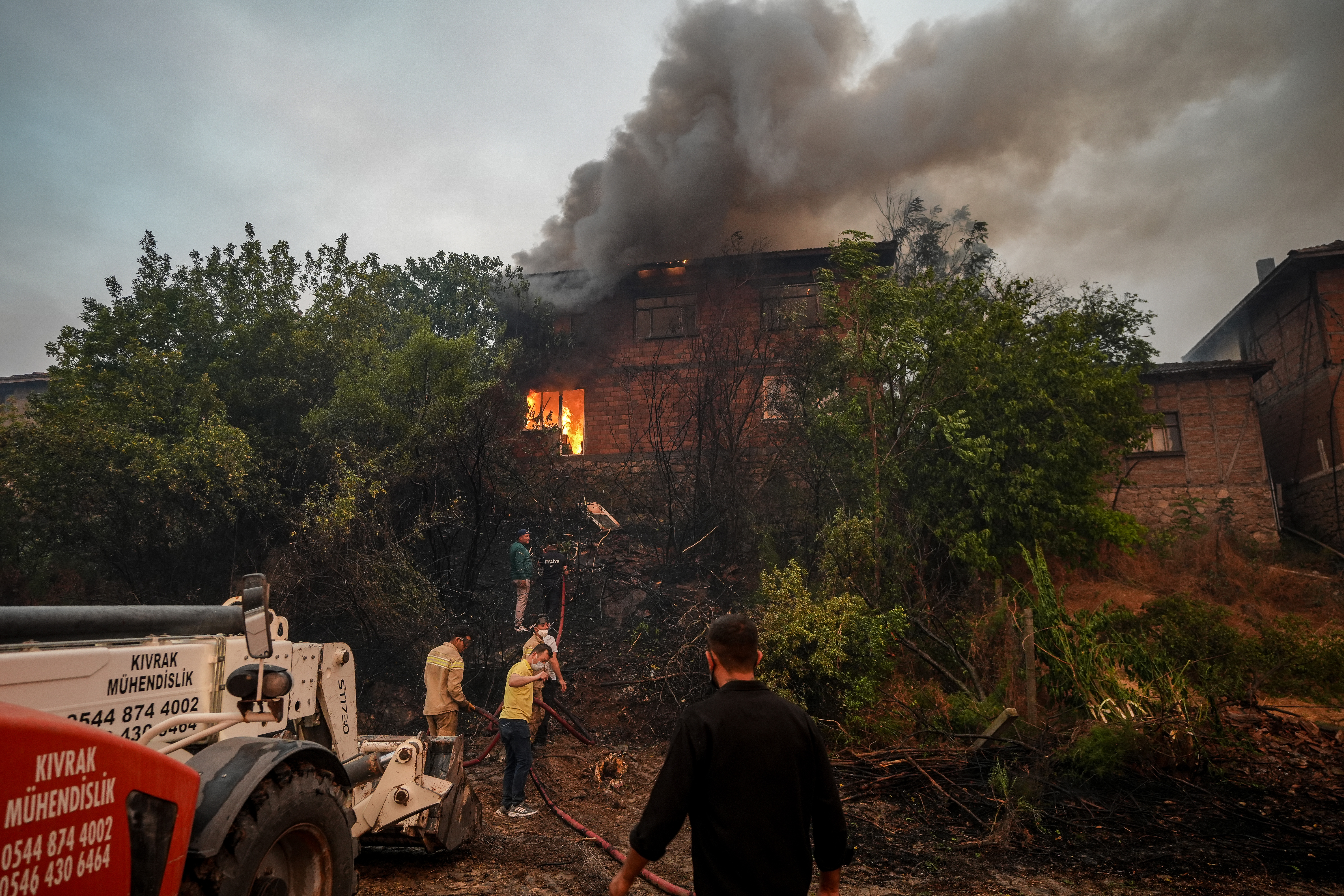 BILECIK, TURKIYE - JULY 23: Flames and smoke rise from a house in Selcik village after a forest fire, which reignited due to strong winds, spread from Sakarya's Geyve district to Bilecik and reached residential areas in Osmaneli district of Bilecik, Turkiye on July 23, 2025. Firefighting teams continue efforts to contain the blaze. ( Sergen Sezgin - Anadolu Agency )