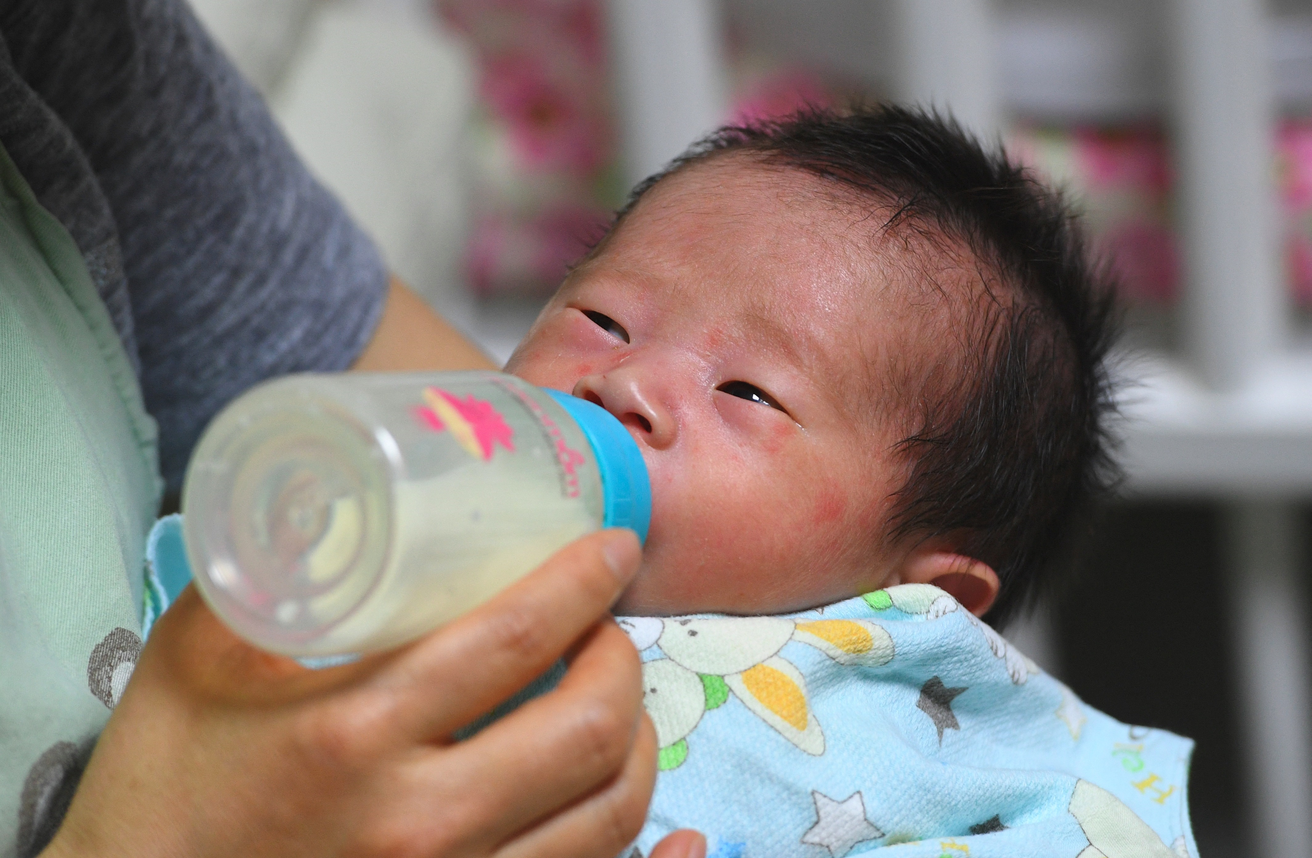 Social workers bottle-feeding a baby.