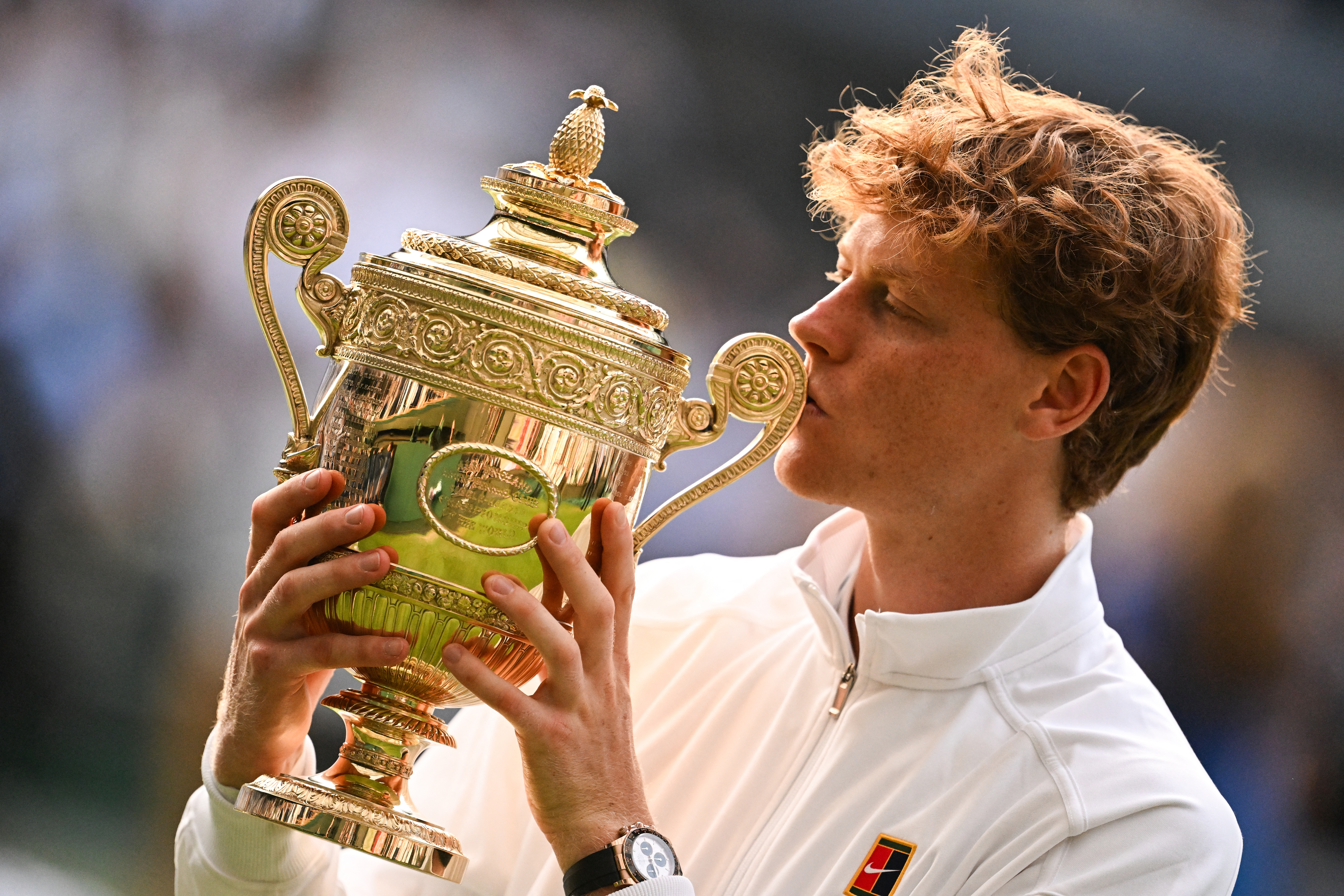 Italy's Jannik Sinner kisses his winner's trophy as he poses for pictures following his victory against Spain's Carlos Alcaraz at the end of their men's singles final tennis match on the fourteenth day of the 2025 Wimbledon Championships at The All England Lawn Tennis and Croquet Club in Wimbledon, southwest London, on July 13, 2025. (Photo by Kirill KUDRYAVTSEV / AFP) / RESTRICTED TO EDITORIAL USE