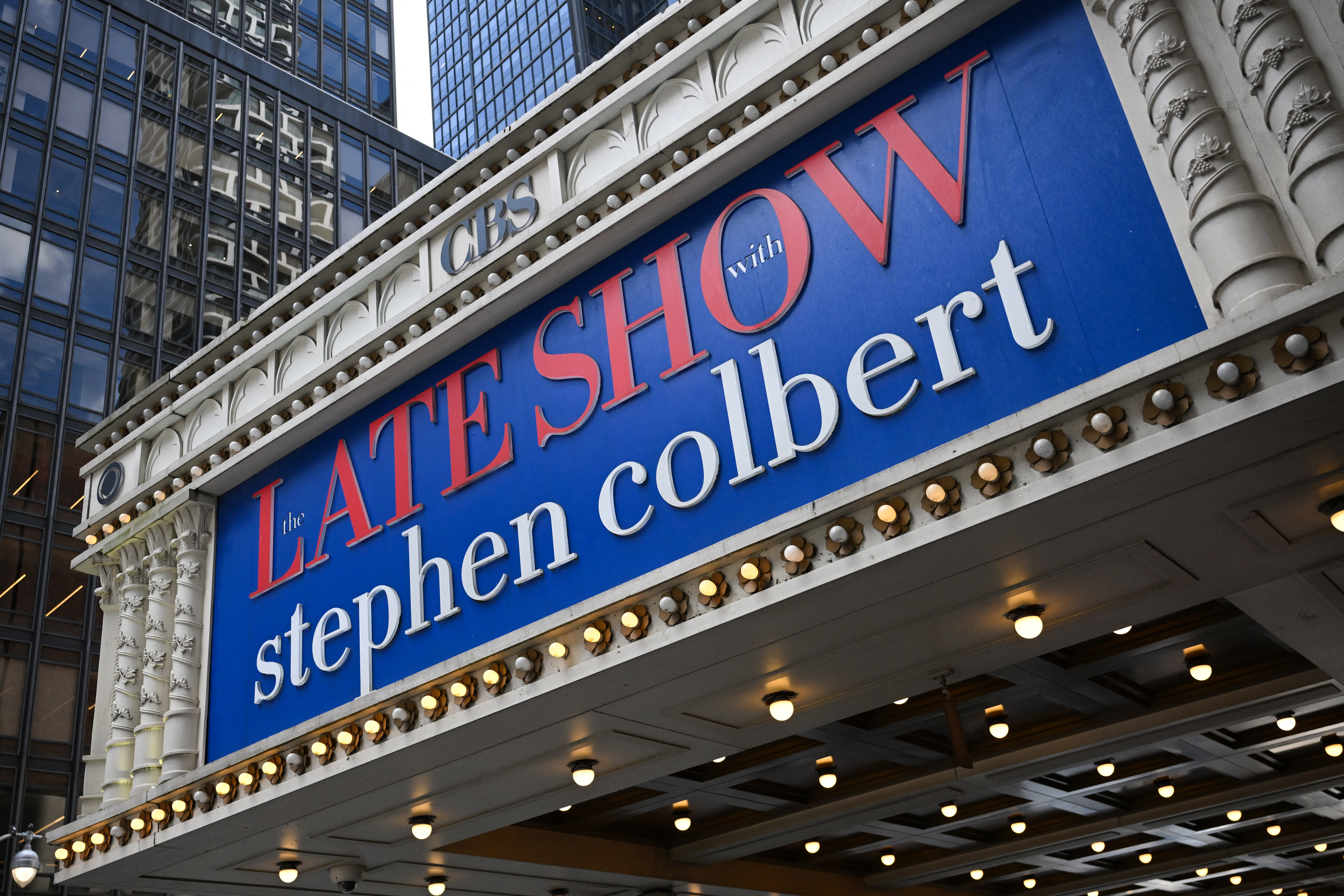 A marquee featuring "The Late Show with Stephen Colbert" is seen outside the Ed Sullivan Theater, where Colbert's show is produced, in New York City on July 18, 2025. Stephen Colbert's "The Late Show", long a staple of late night US television, will end in 2026, the CBS network said on July 17, days after the comedian blasted parent company Paramount's $16 million settlement with President Donald Trump as "a big fat bribe." CBS said in a statement the cancellation was "purely a financial decision against a challenging backdrop in late night," and was "not related in any way to the show's performance, content or other matters happening at (parent company) Paramount." (Photo by ANGELA WEISS / AFP)