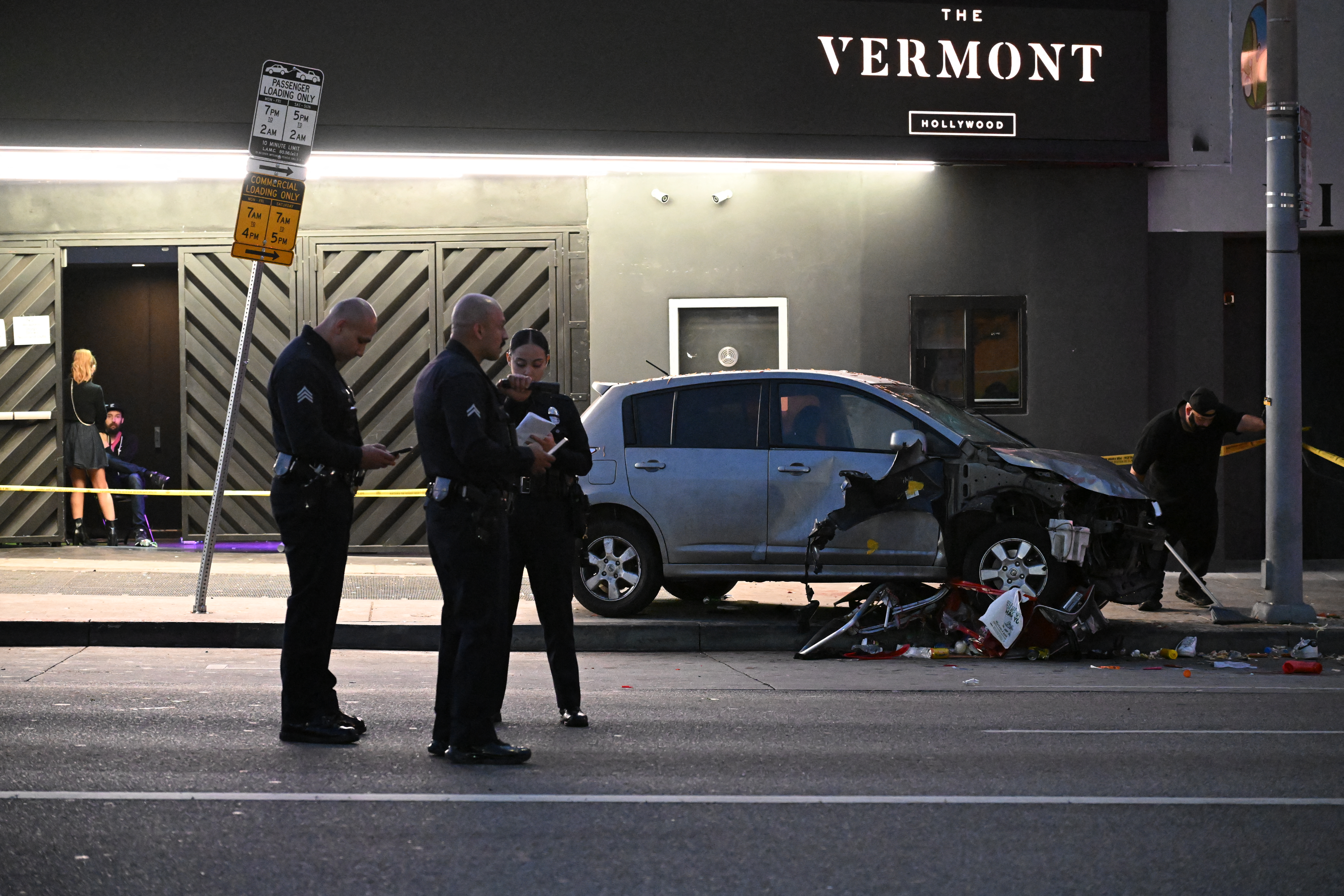 a smashed up car underneath a sign that says Vermont Hollywood