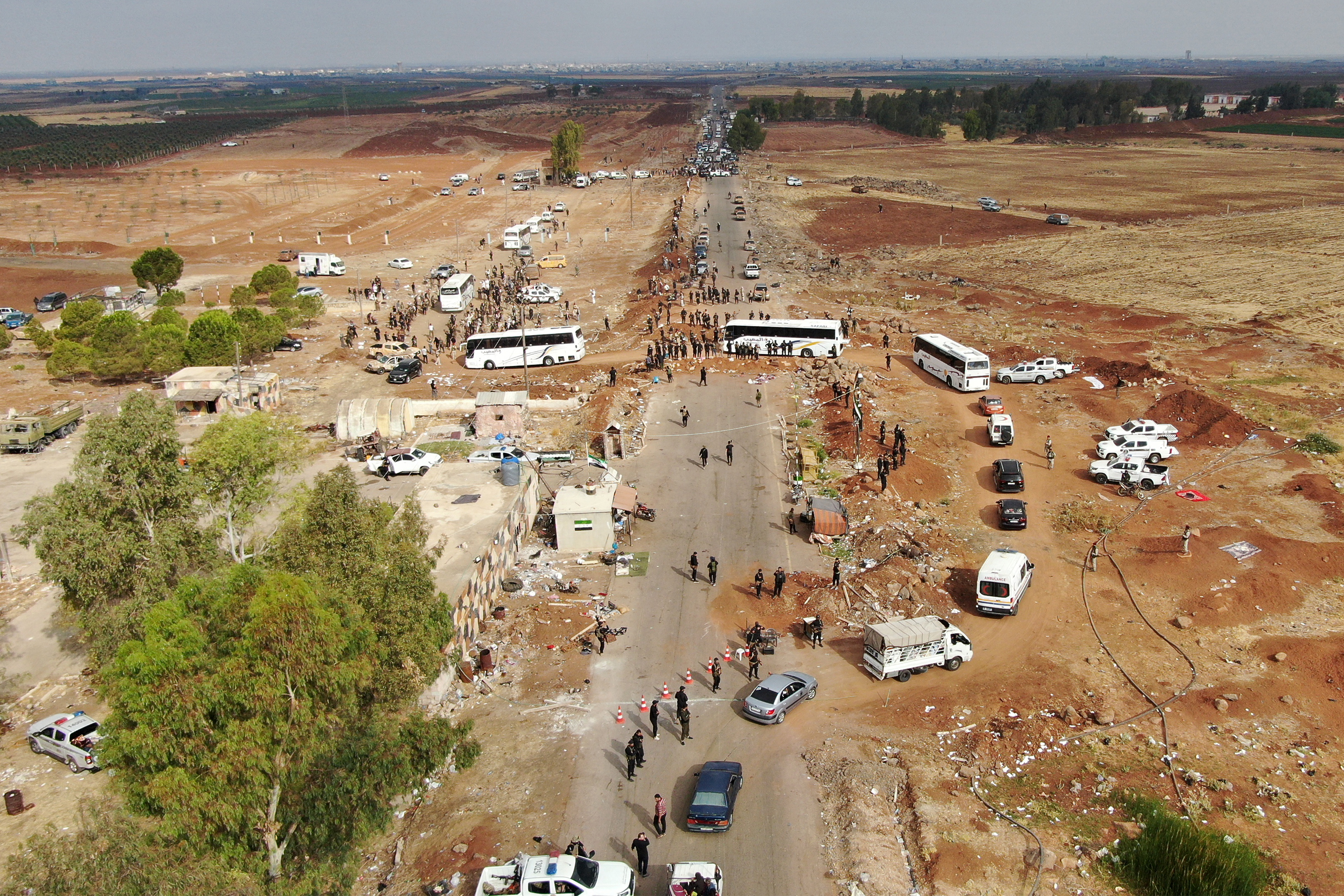This aerial view shows members of the Syrian government security forces deploying on a road in Taarah, in Syria's southern Sweida province on the way to Daraa, on July 21, 2025. 