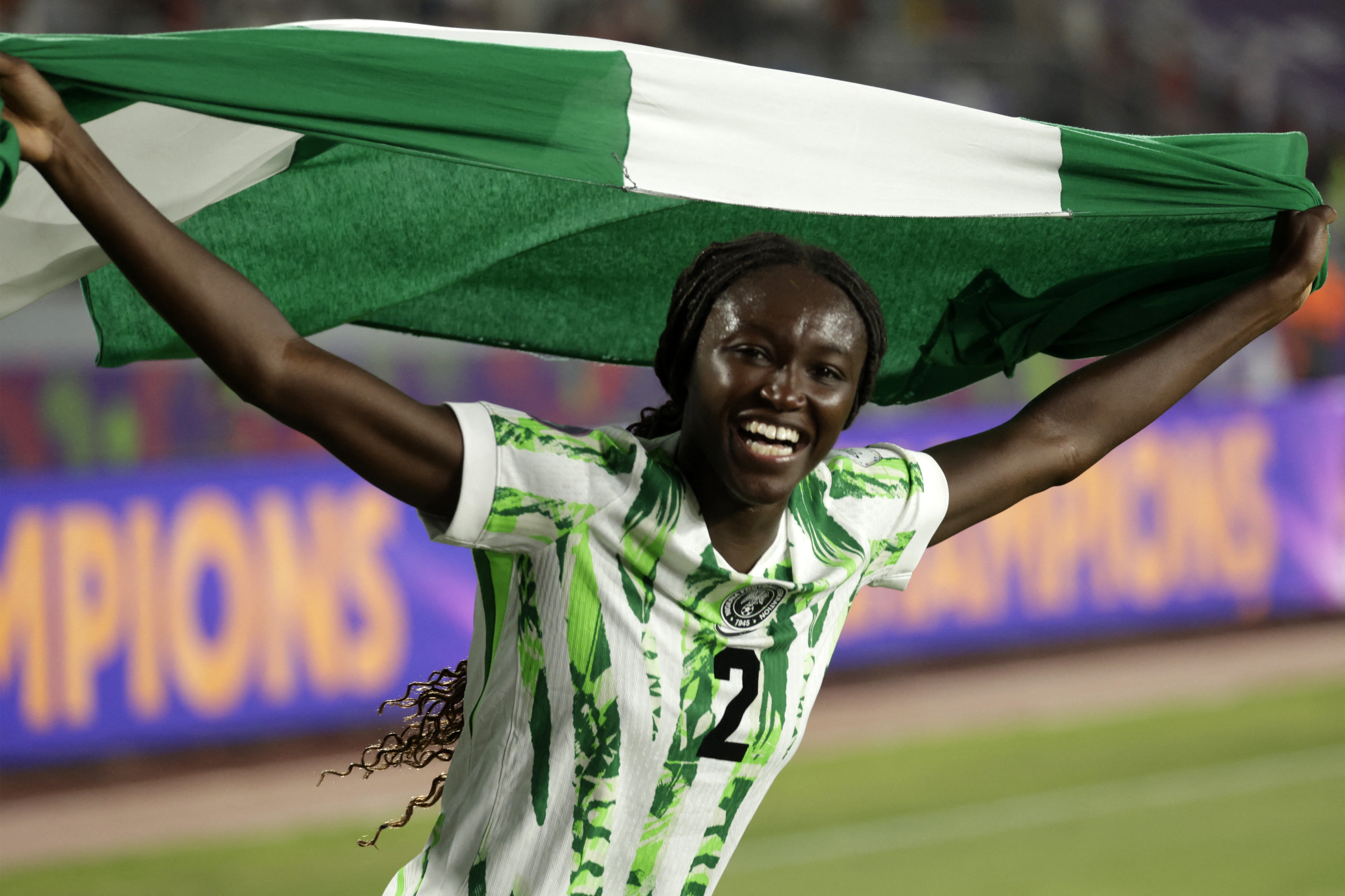 Nigeria's midfielder #02 Rinsola Babajide celebrates with a national flag after winning the 2025 Women's Africa Cup of Nations final football match against Morocco