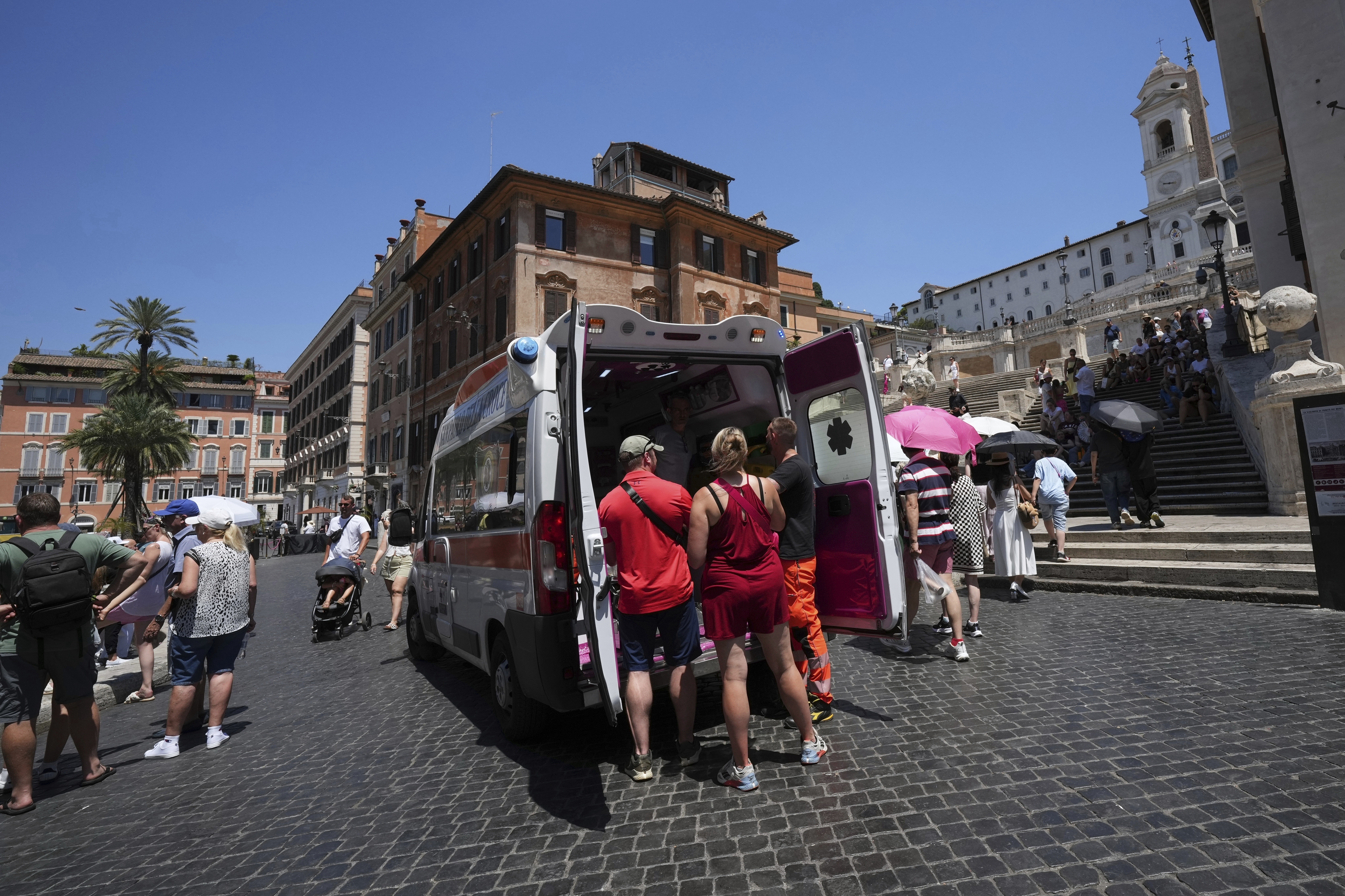 Paramedics provide aid to tourists and residents with an ambulance, next to the historical Spanish Steps, in Rome, Italy on July 1, 2025.