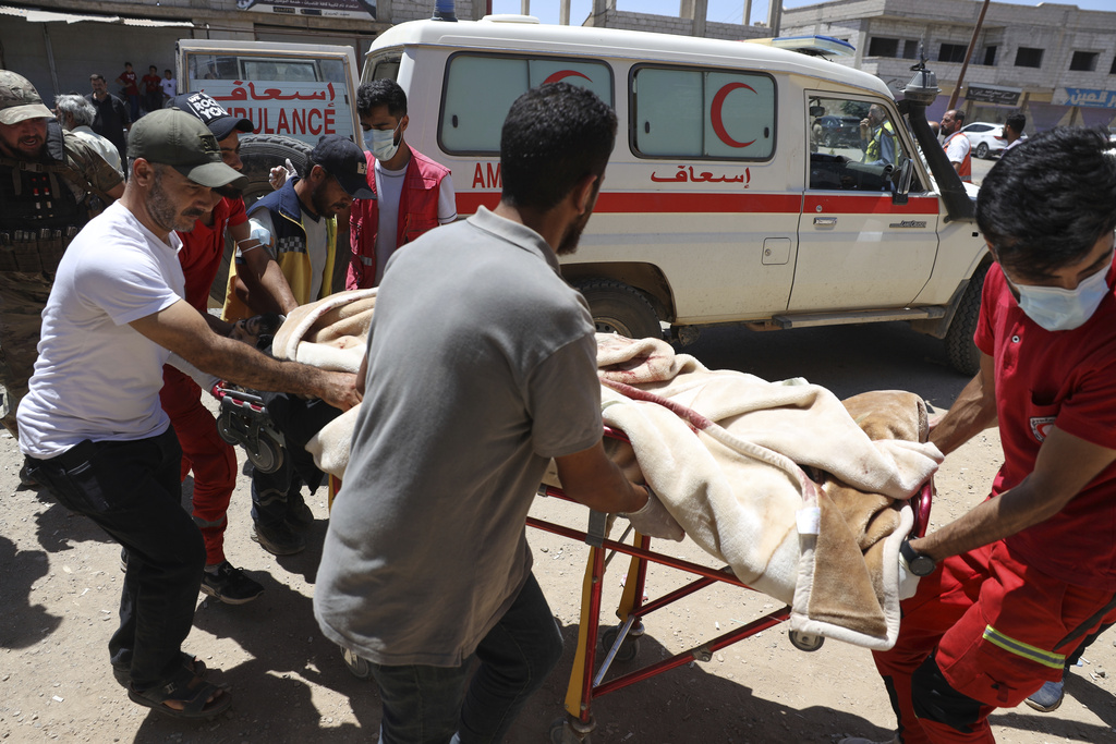 Red Crescent volunteers carry an injured government soldier.