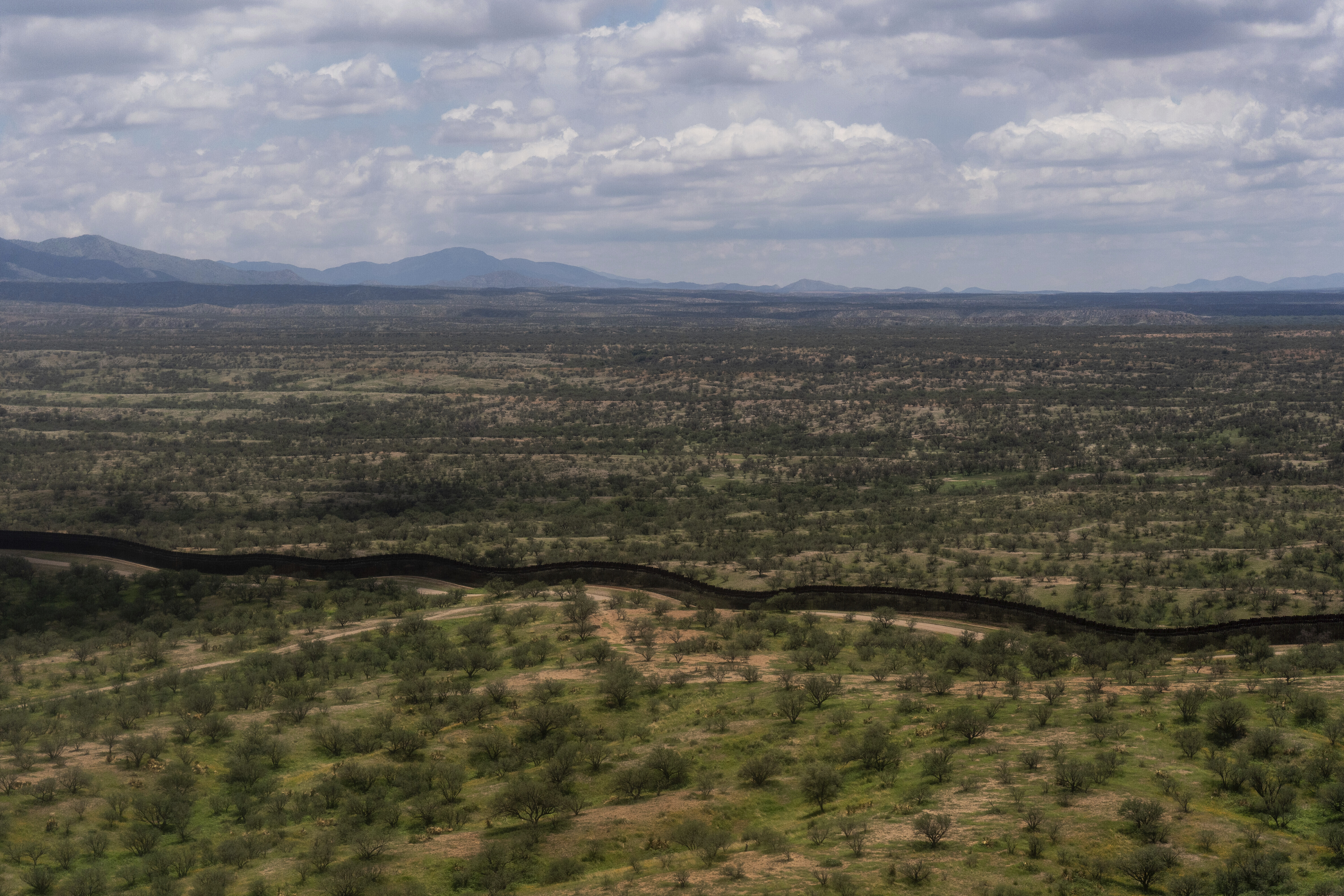 The U.S.-Mexico border fence stretches through remote desert terrain near Nogales, Ariz., Tuesday, July 22, 2025. (AP Photo/Jae C. Hong)