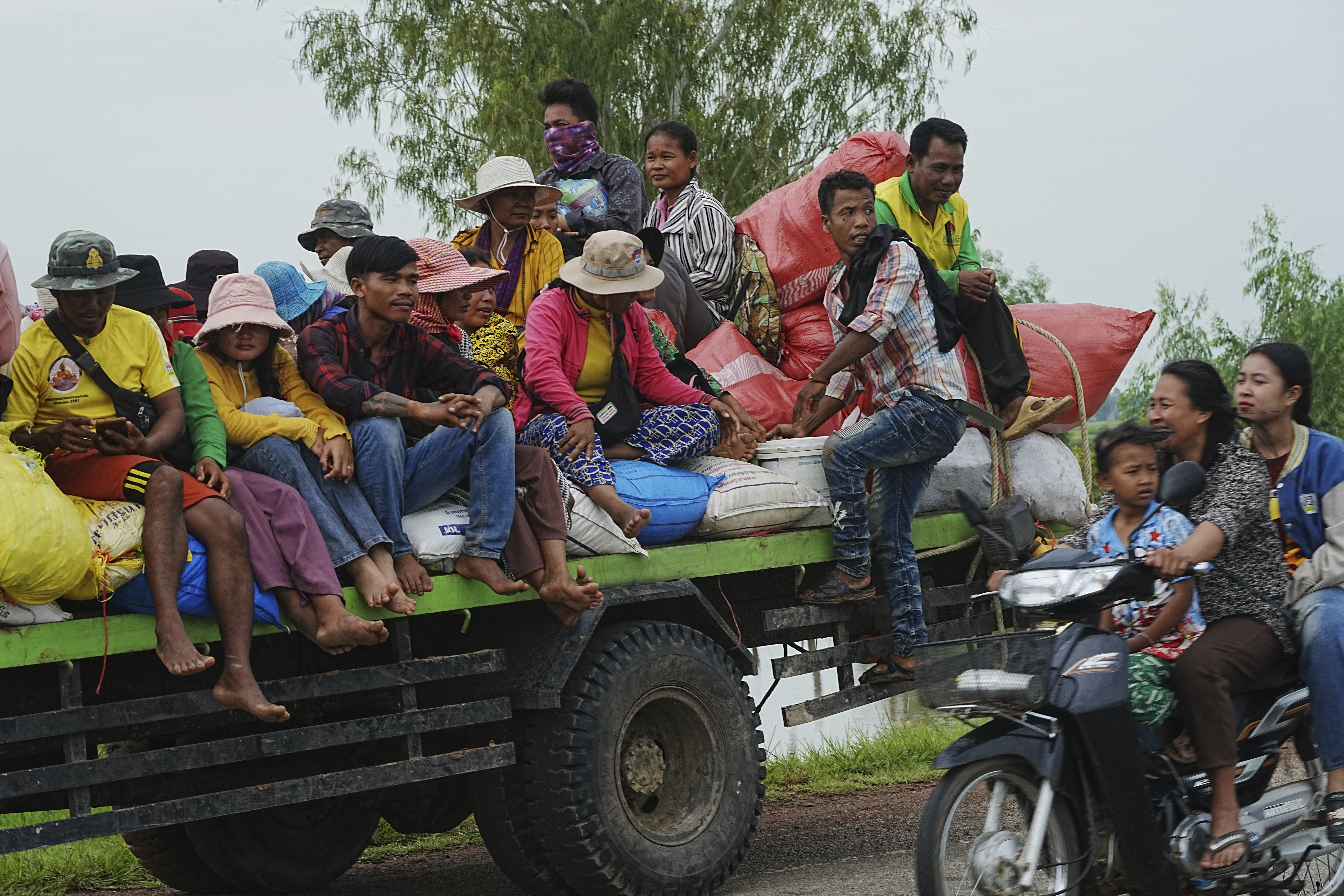 Cambodians sit on a cart of a tractor as they take refuge.