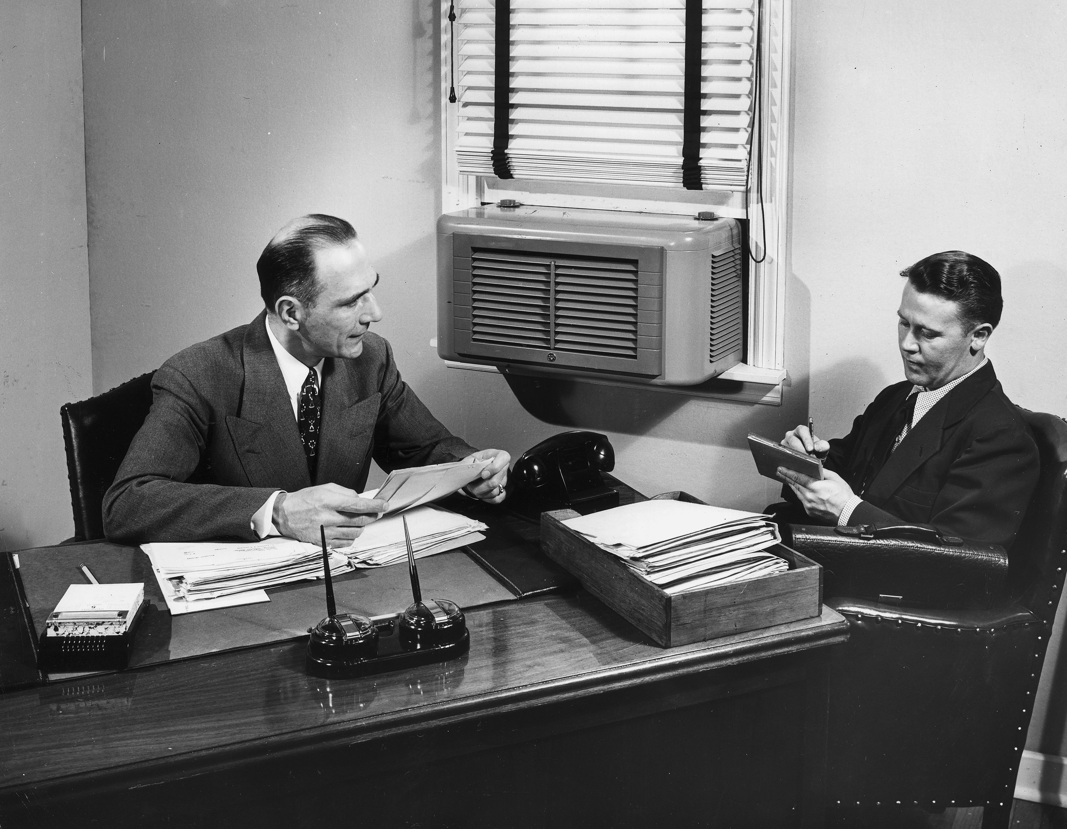 An air conditioner is mounted in the window of an offic